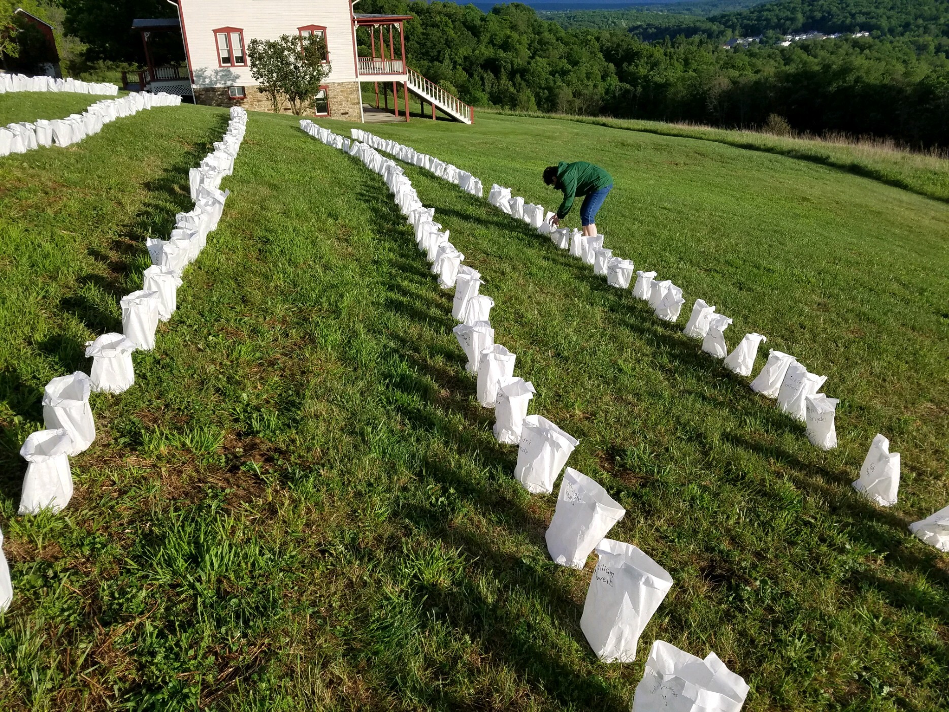 A park volunteer lighting luminaries.