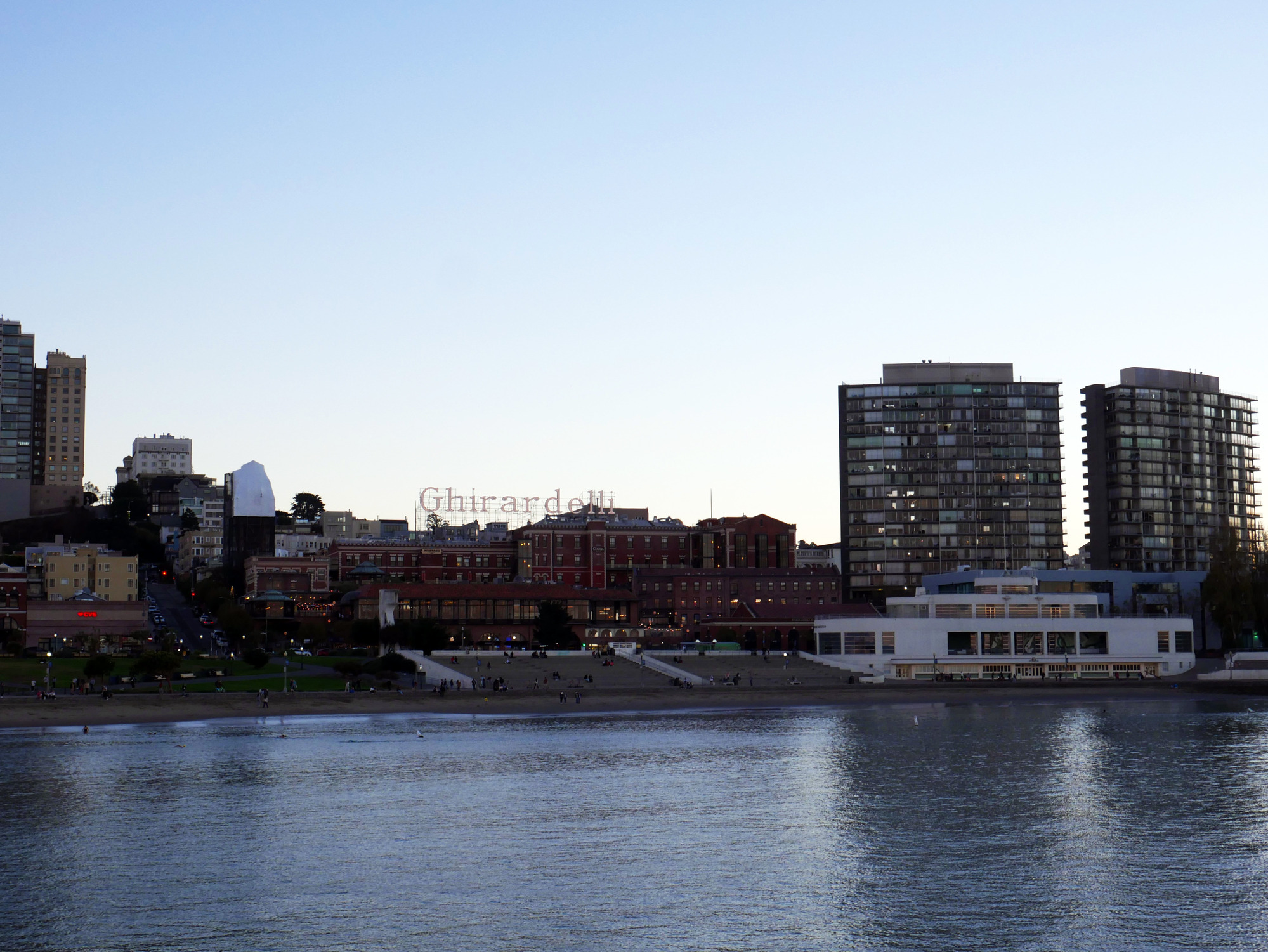 a view of the Maritime Museum building and Ghirardelli Square as seen from the deck of Balclutha at sunset.