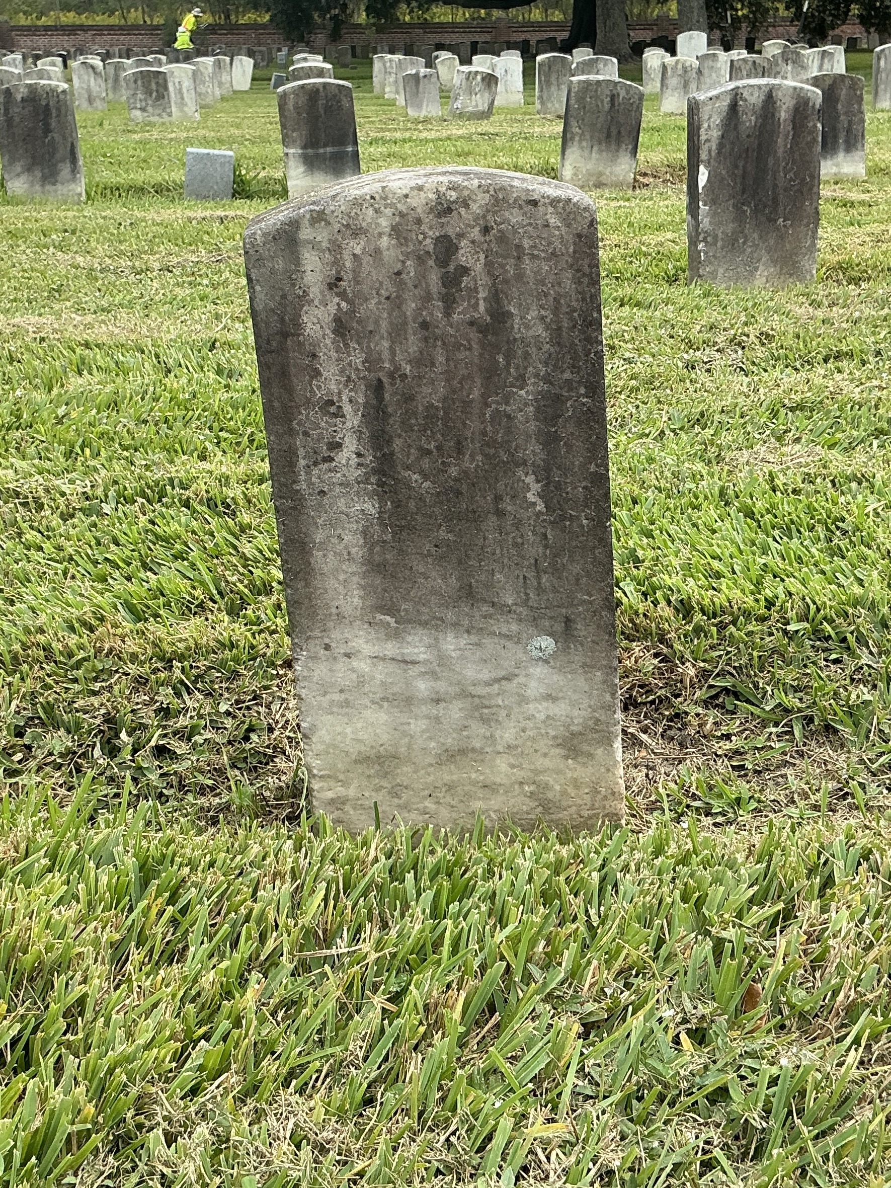 Back of historic upright marble headstone with recessed shield face.