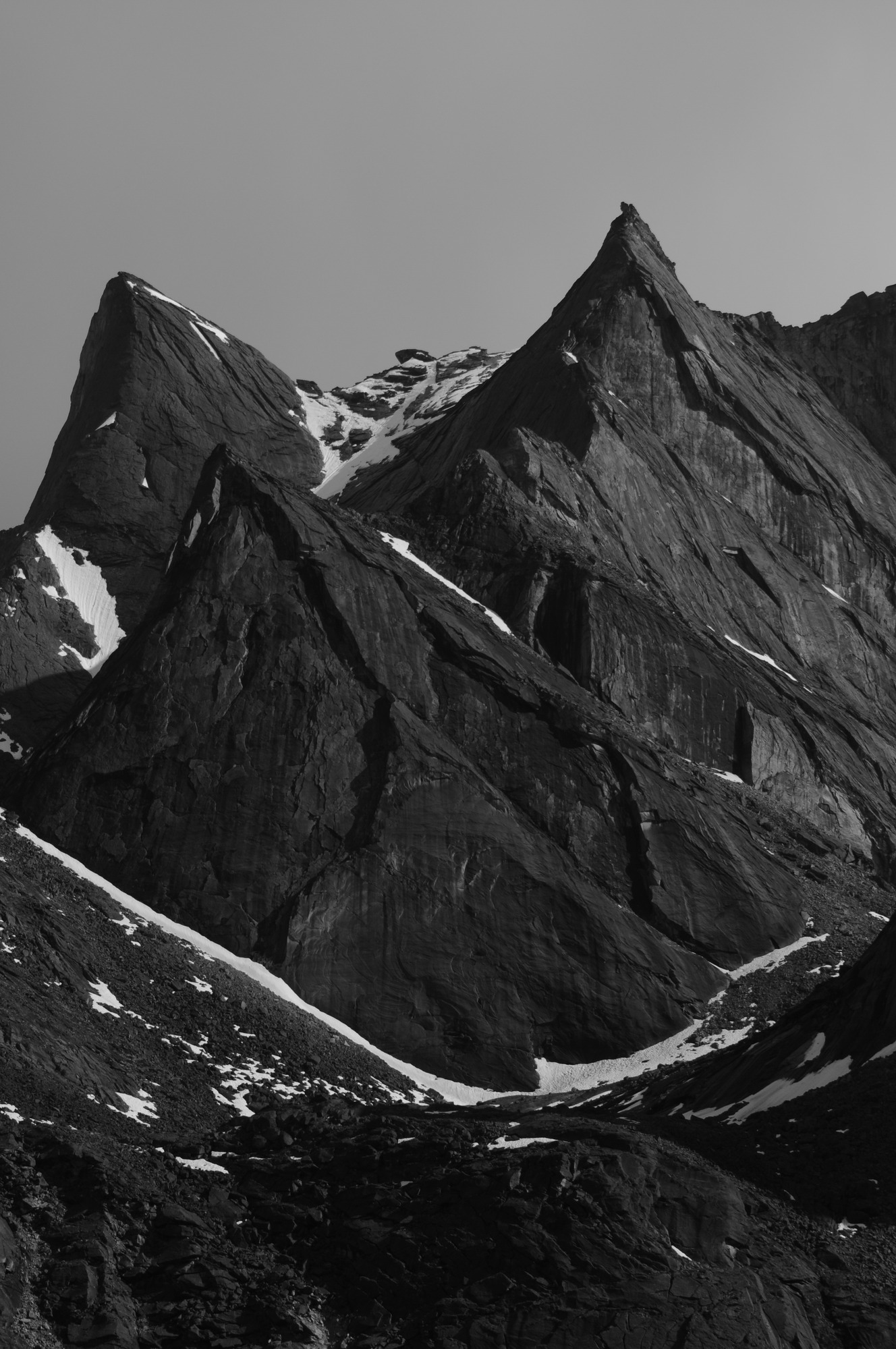 Three sharp and pointed mountains partial covered in snow.