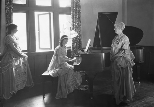 Rehearsing for Christmas dinner. Mary Curry Tresidder on the far left and Miss Tresidder at the piano.