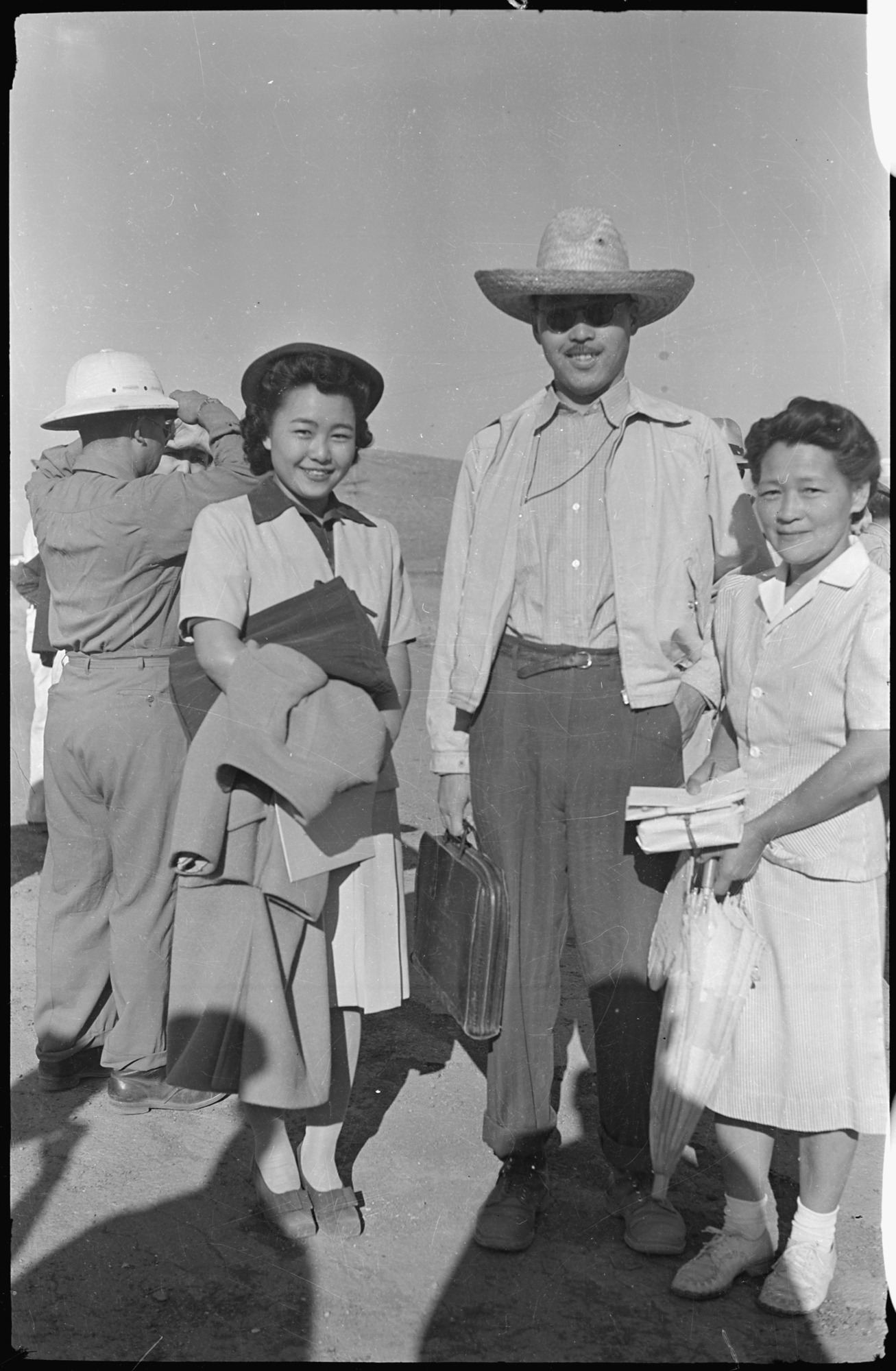 Mrs. Ohmura and Father Dai bid goodbye to Mae Ohmura who leaves for work on the outside