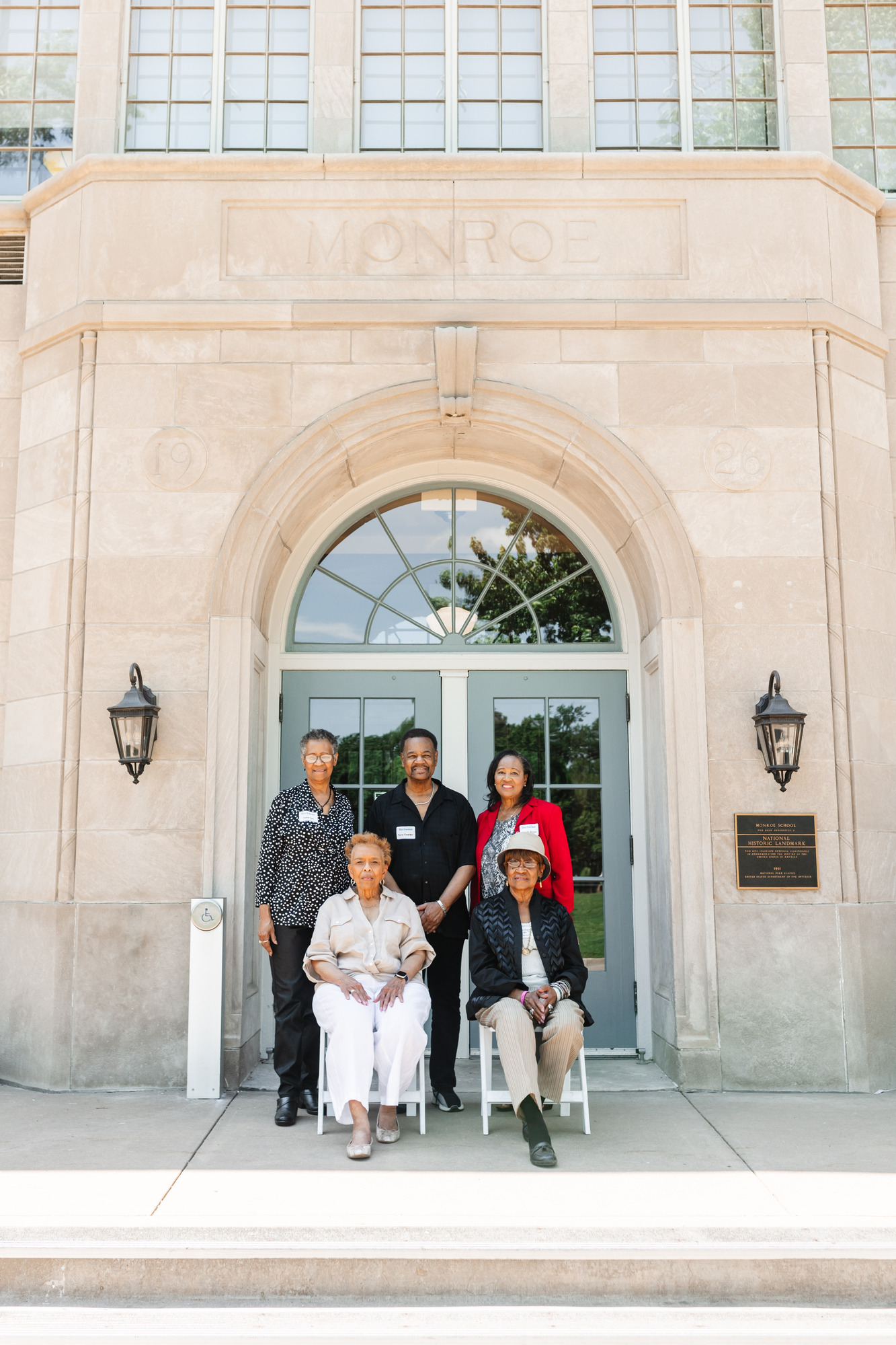 A group of 5 adult African Americans can be seen sitting in front of Brown v. Board of Education NHP's front entrance. They are all former students of Buchanan Elementary School, a formerly segregated school for African American children in Topeka Kansas.