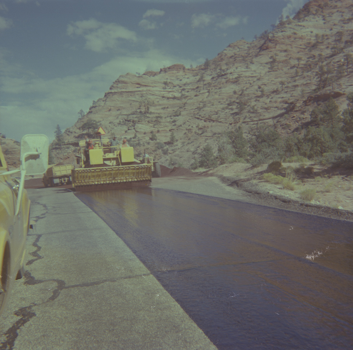 Workers operating chipsealer to chipseal roads in Zion.