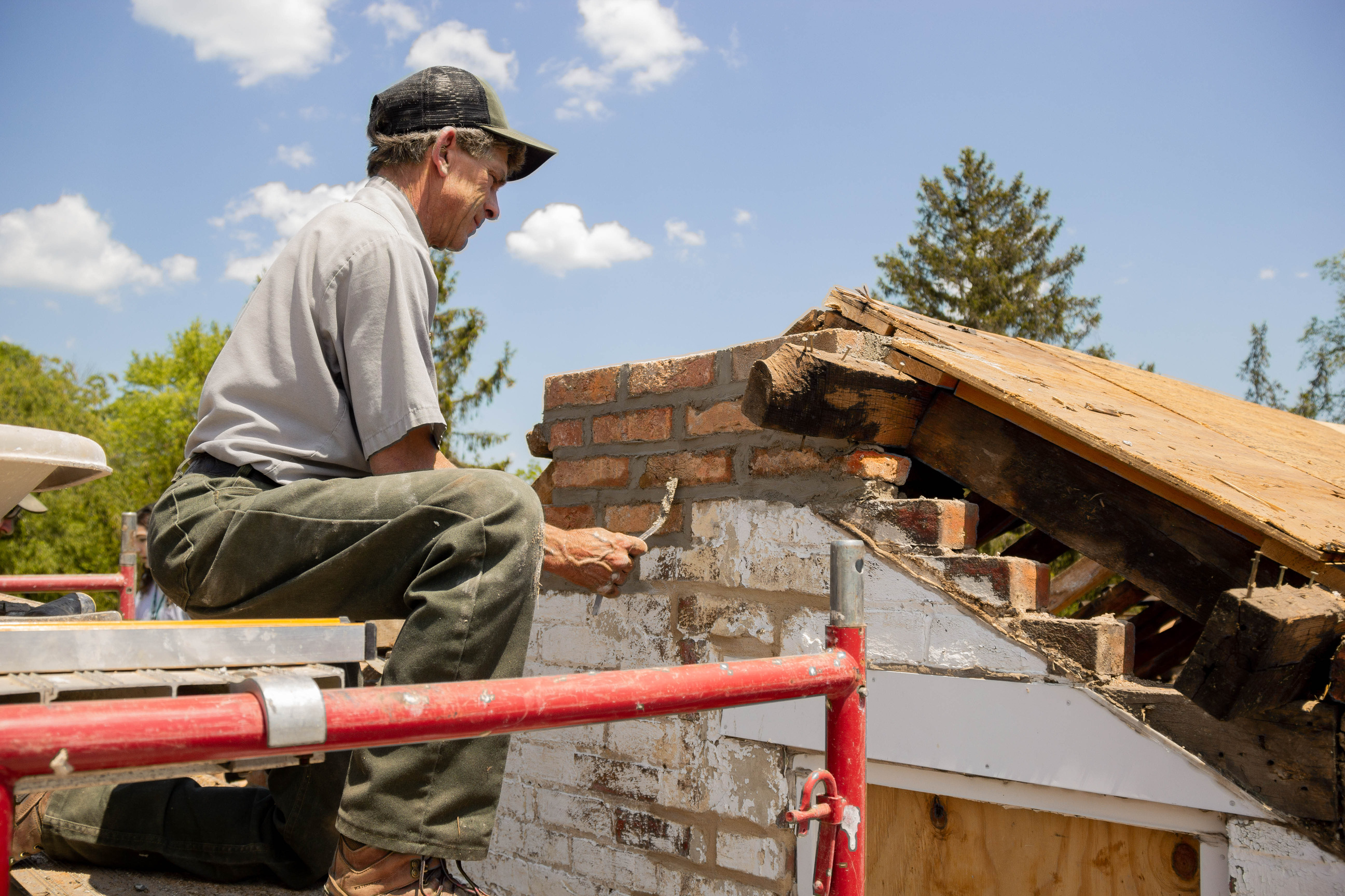 NPS mason reconstructs the missing chimney for the west gable wall. 