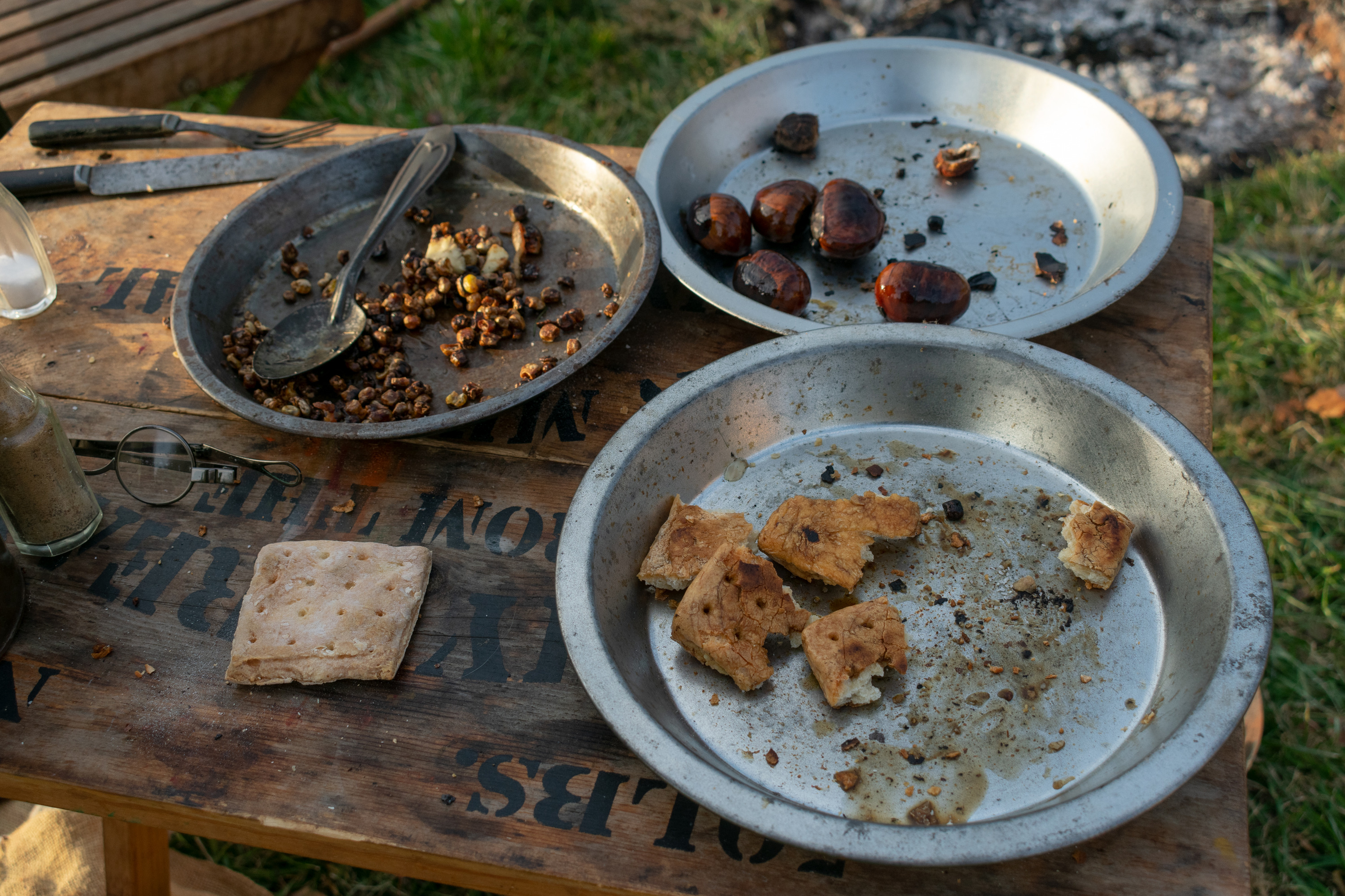 Three plates of food in tin skillets.