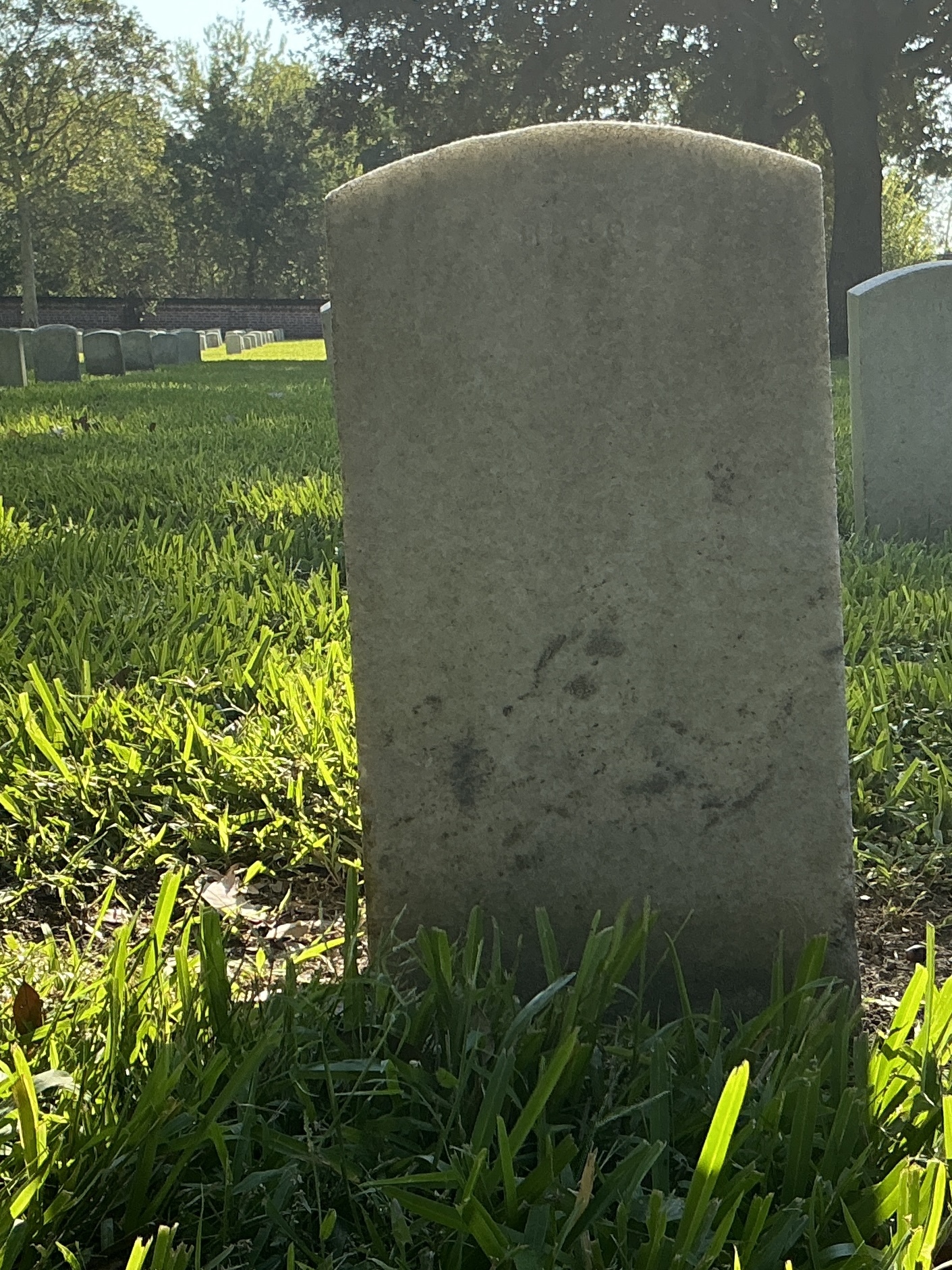 Back of upright marble headstone with flat face.