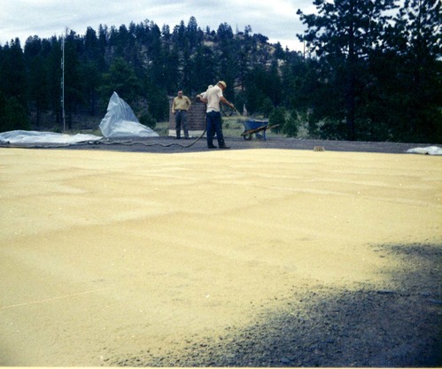 Two men watching as third man sprays foam sealant during reroofing project. Bryce Canyon National Park.
