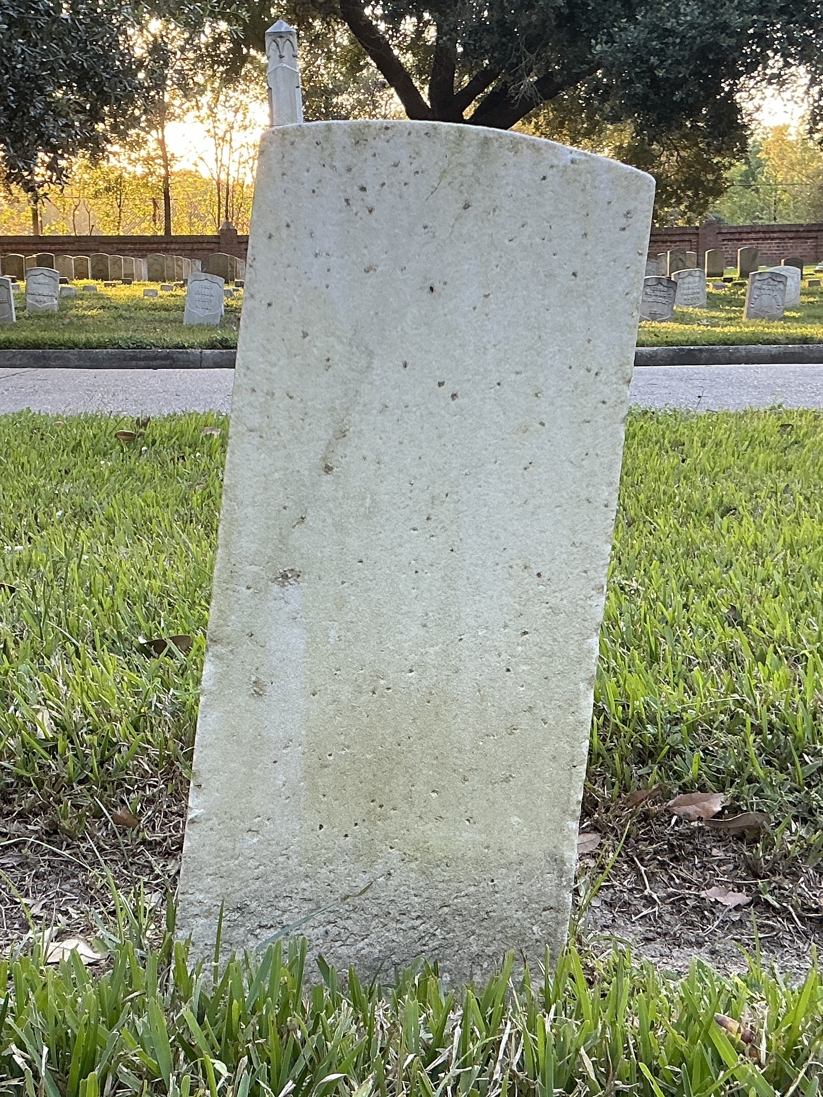 Back of historic upright marble headstone with recessed shield face.