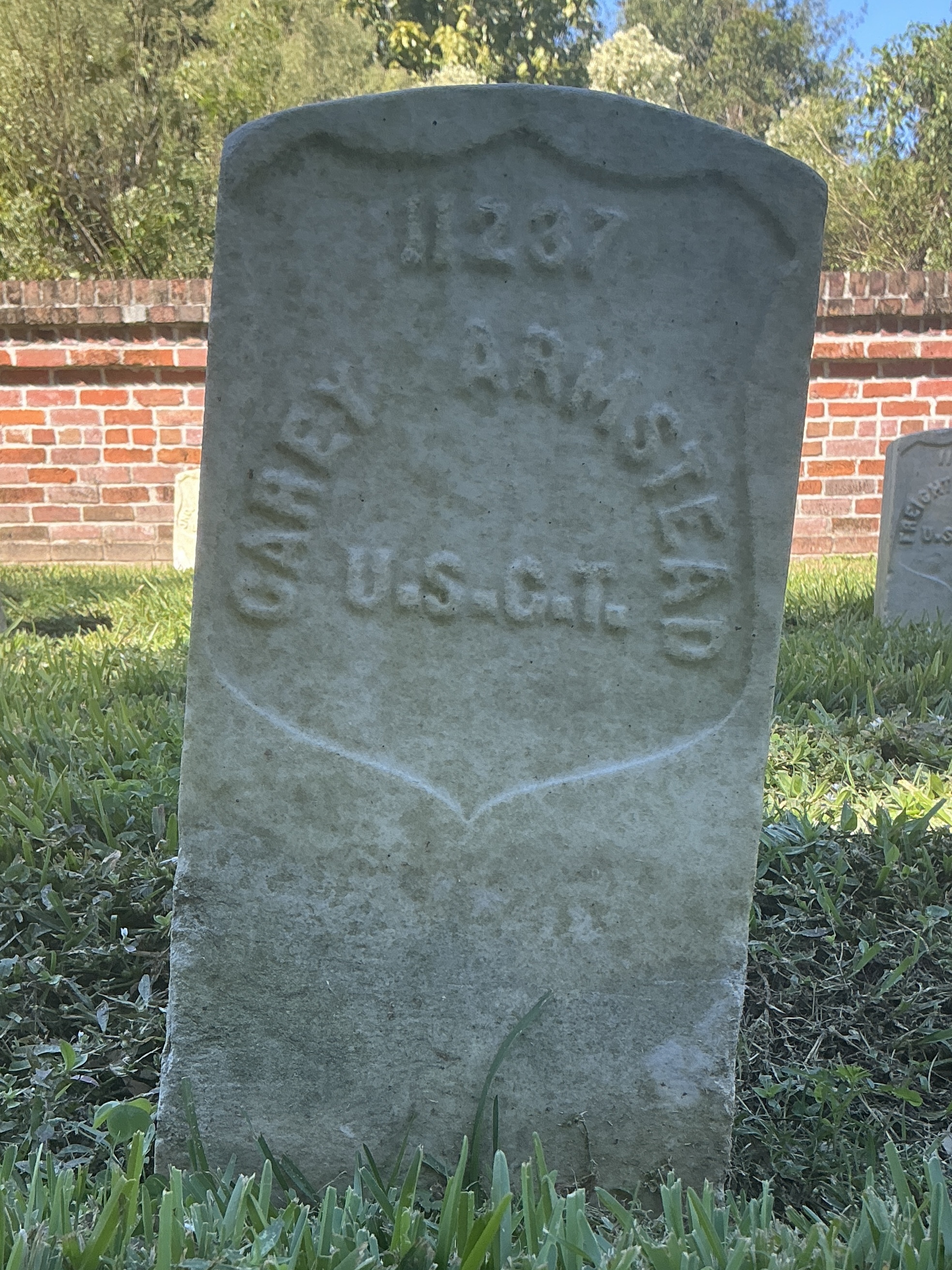 Front of historic upright marble headstone with recessed shield face.