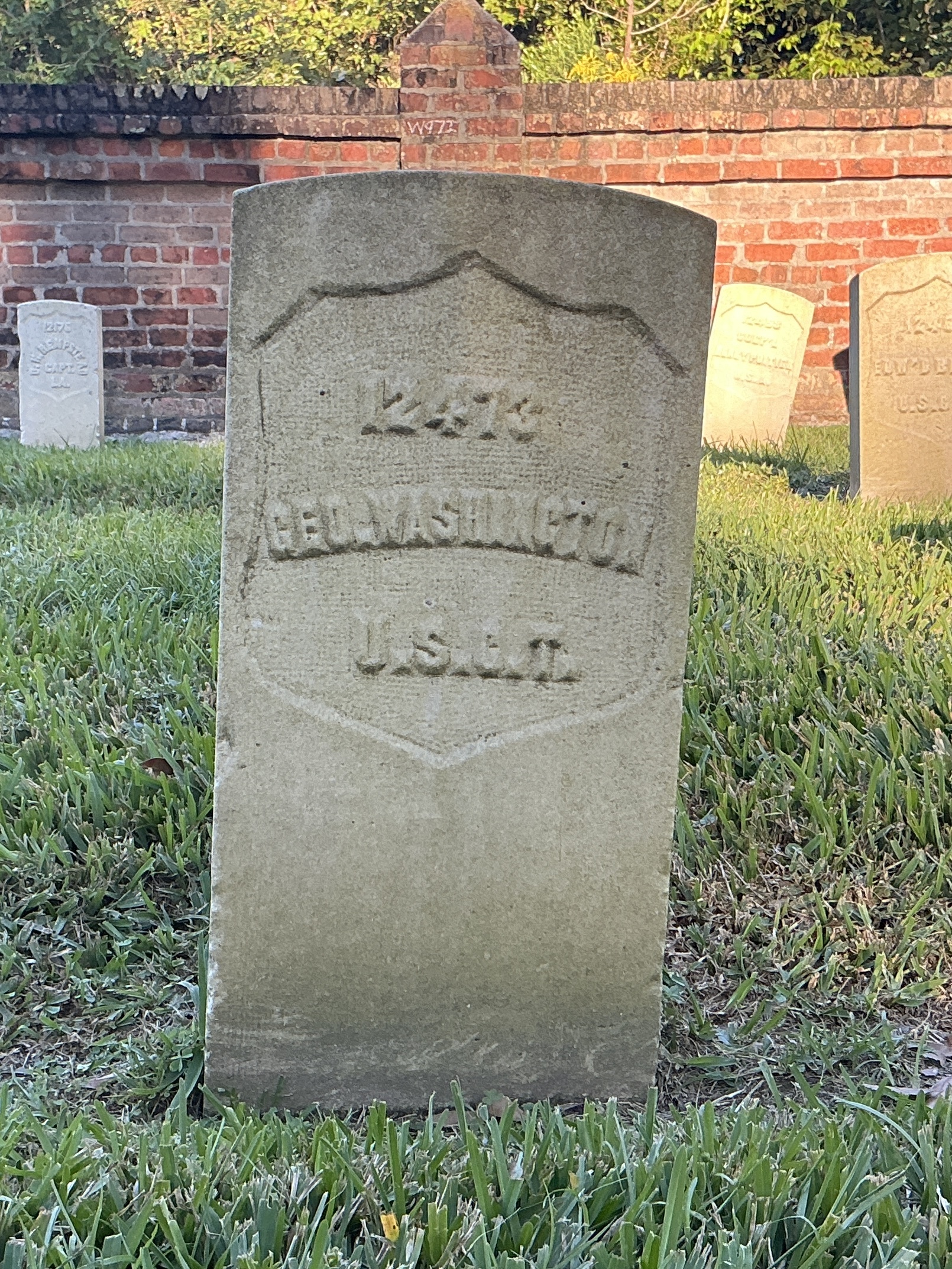Front of historic upright marble headstone with recessed shield face.