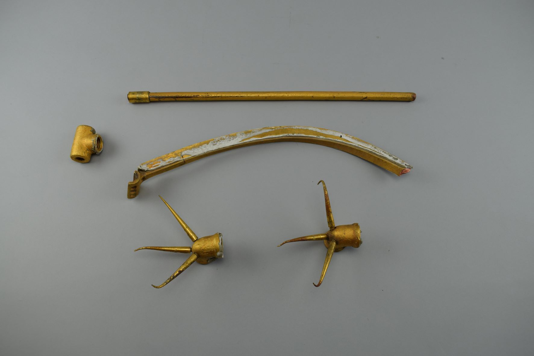 Five gold-colored copper lightning rod system components