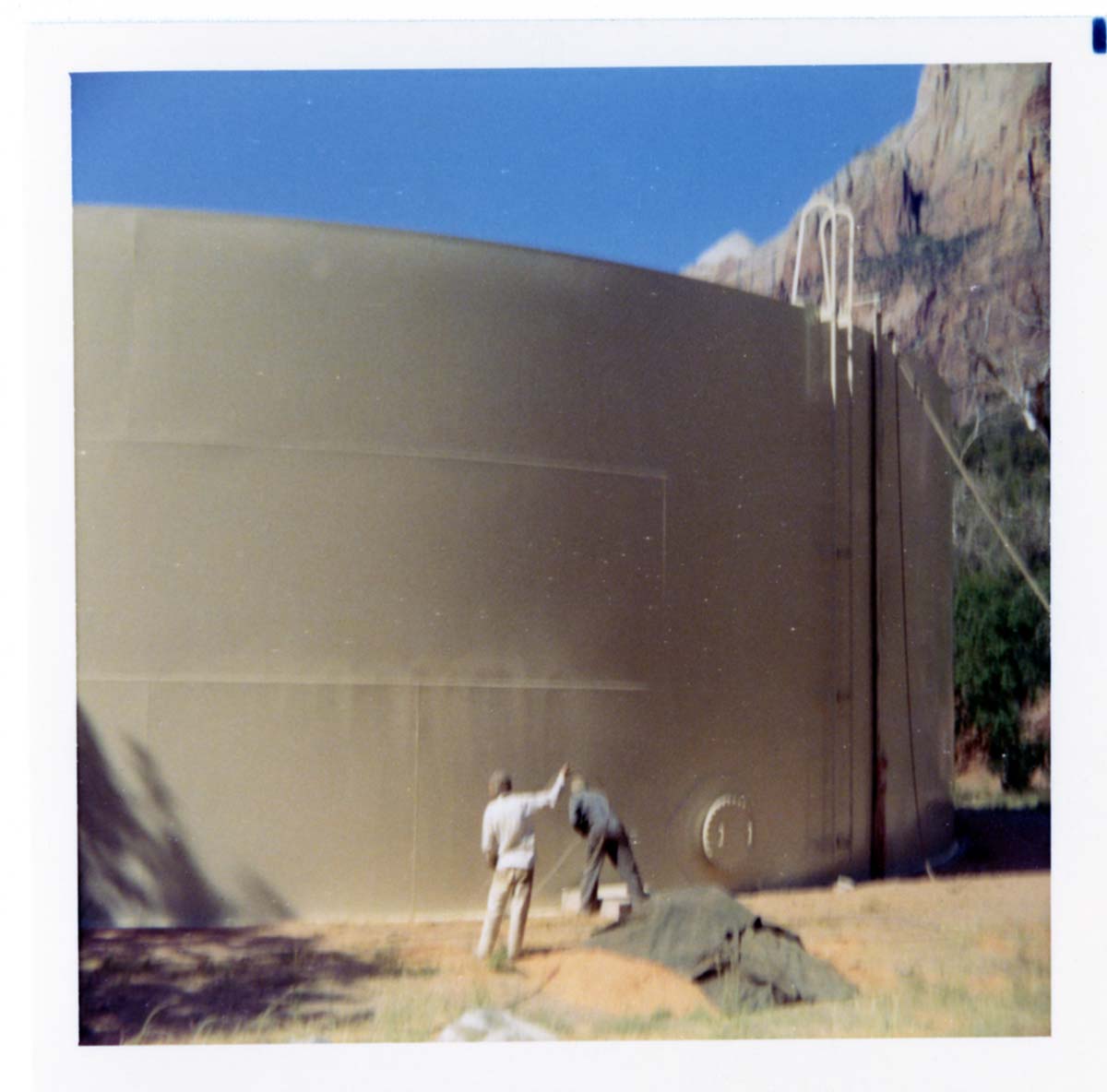 Workers repainting the exterior of the million gallon water tank at Birch Creek.