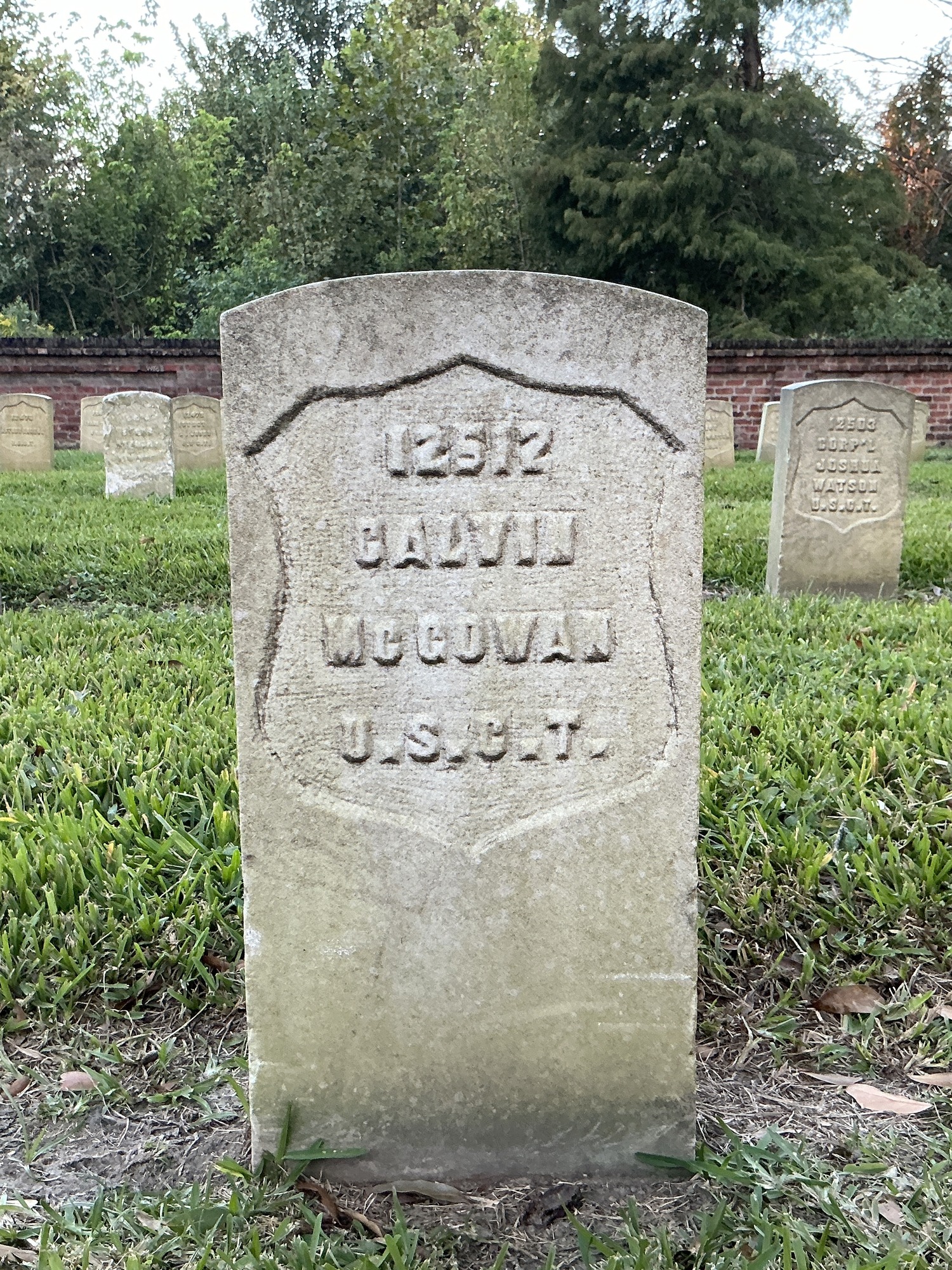 Front of historic upright marble headstone with recessed shield face.