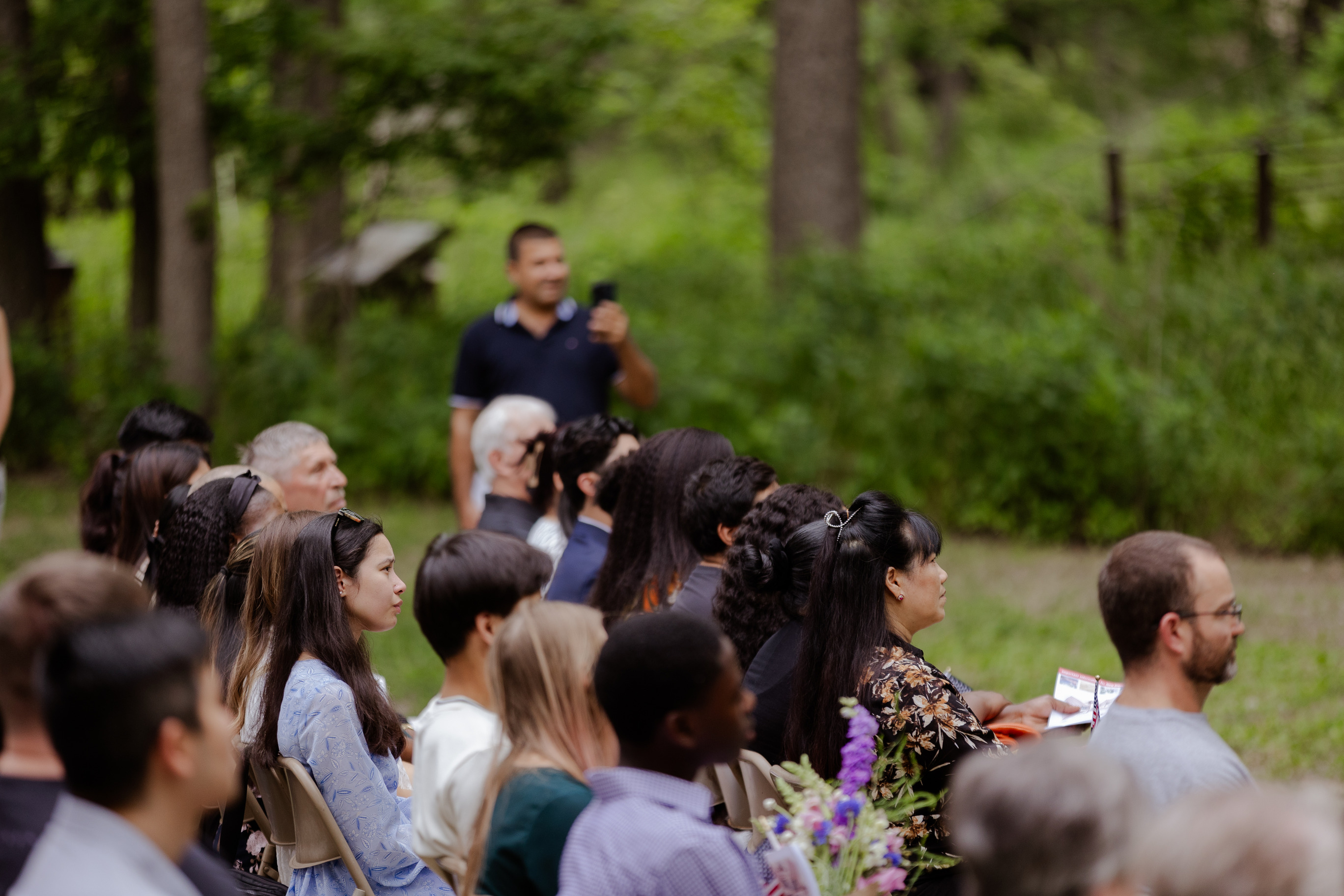 Audience members look toward the speaker with serious expressions on their faces.