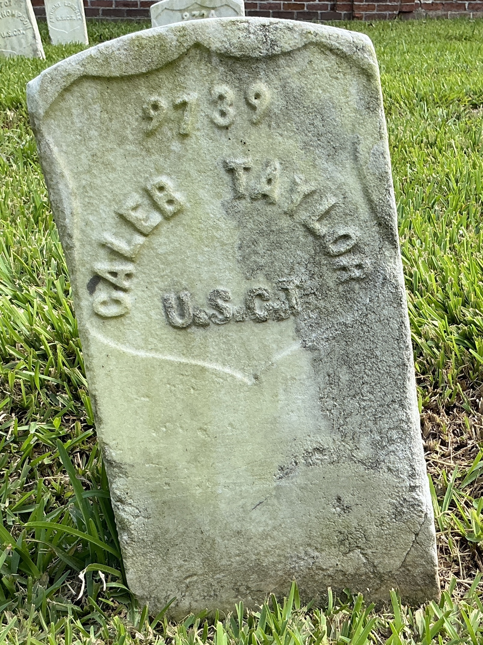 Front of historic upright marble headstone with recessed shield face.