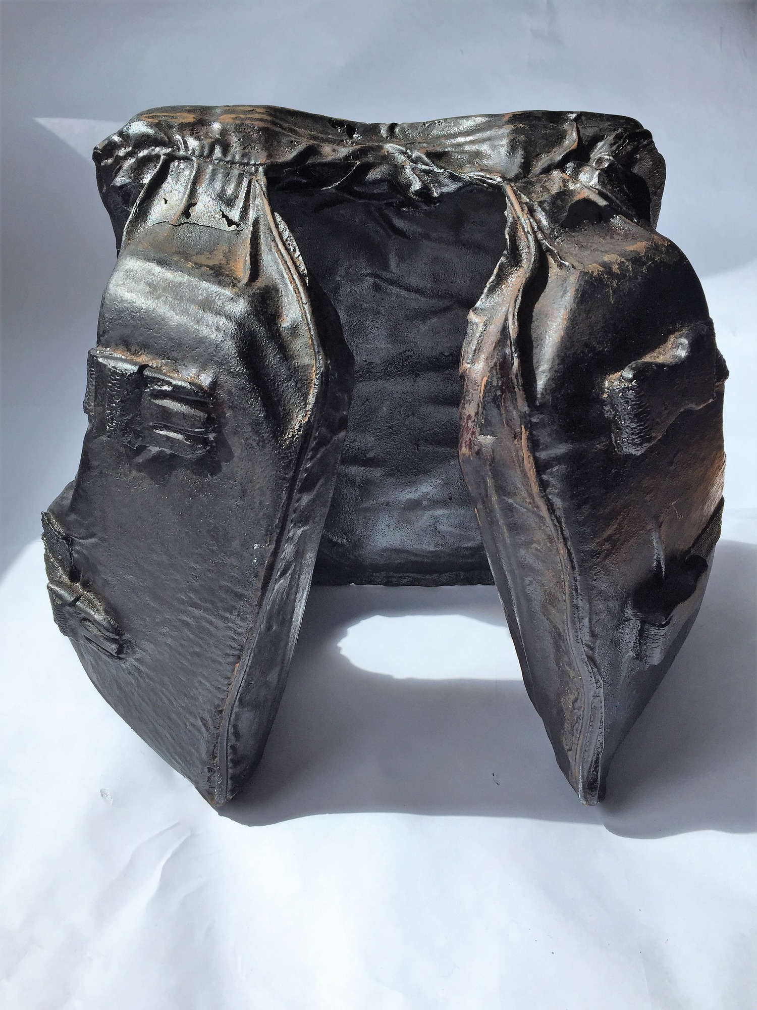A cast iron sculpture of a life jacket complete with clips and seams.