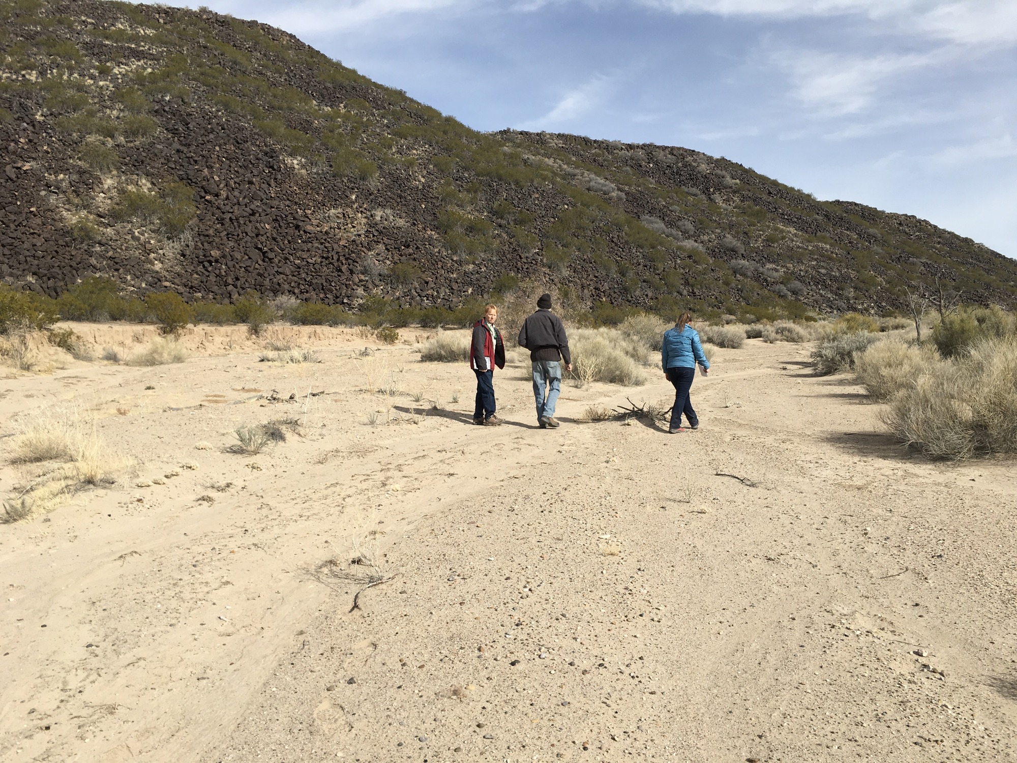 NTIR Staff walks a dry river bed on the El Camino Real de Tierra Adentro National Historic Trail that runs outside of Truth or Consequences, NM