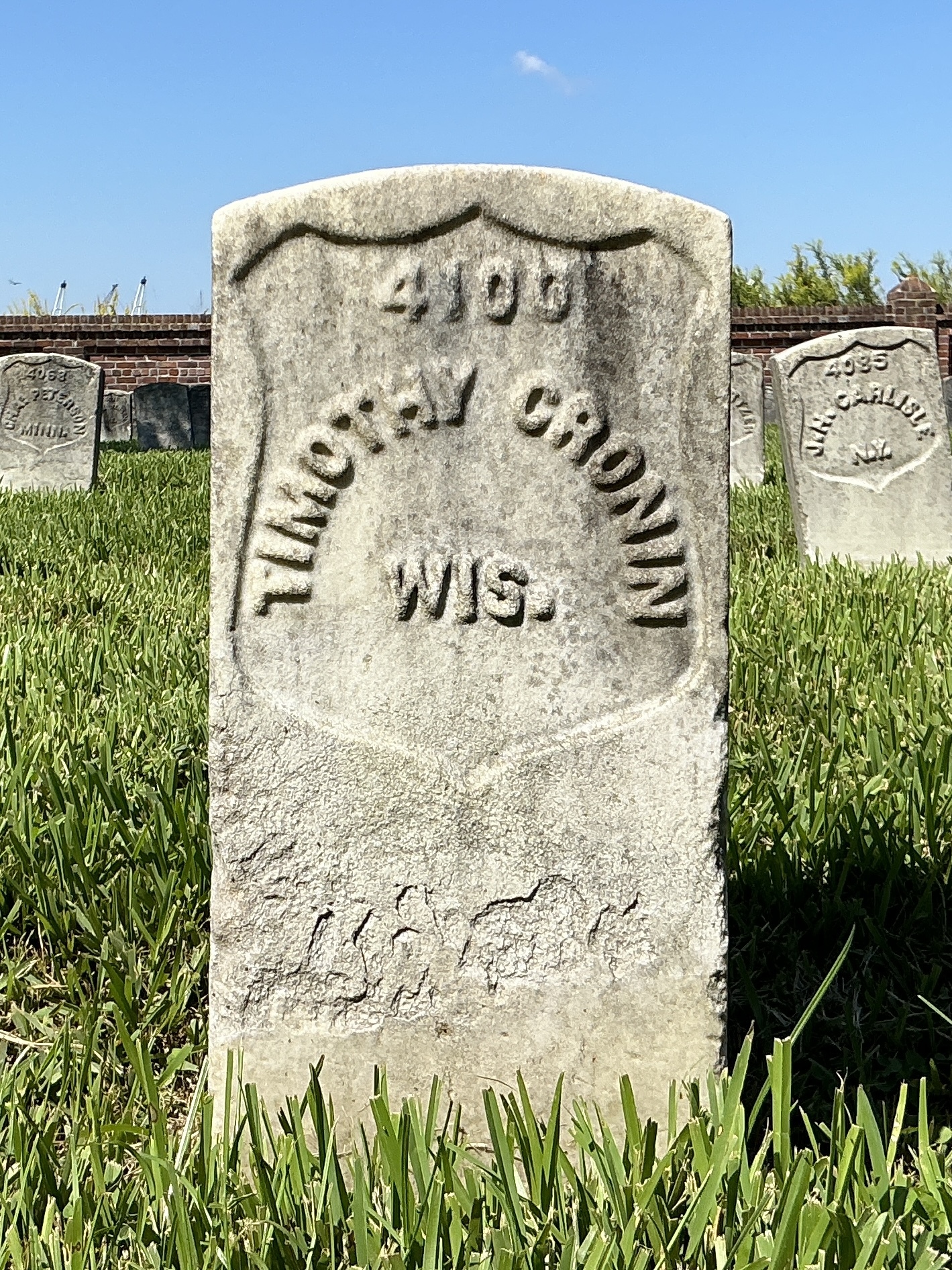Front of historic upright marble headstone with recessed shield face.
