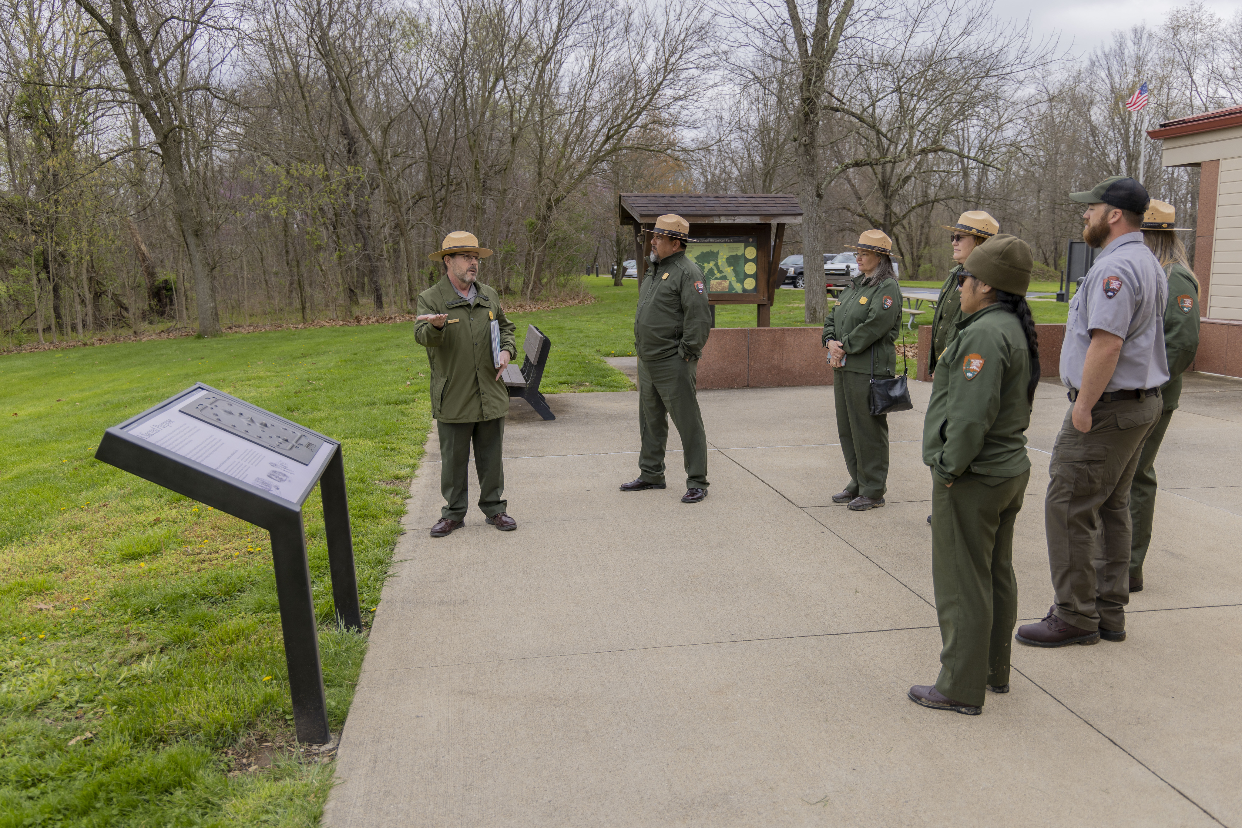 NPS Director Chuck Sams visits Hopewell Culture and listens to a ranger giving a talk.