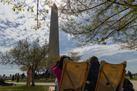 Visitors watch the partial eclipse over the Washington Monument