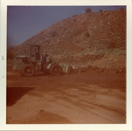 Excavator clearing road at the south entrance to the park during road work.