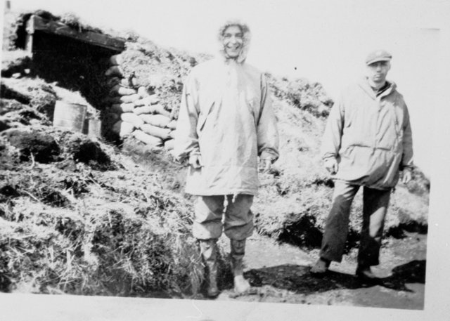 Miller and Bouchette in front of a rudimentary structure