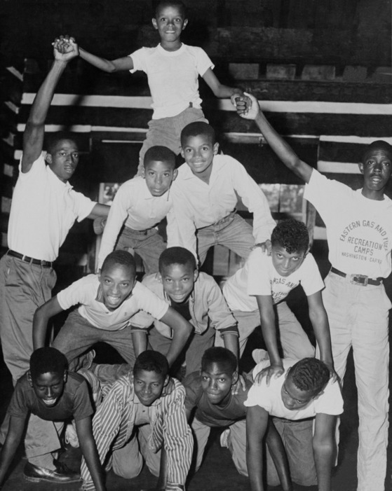 historic photo of kids and camp counselors forming a human pyramid