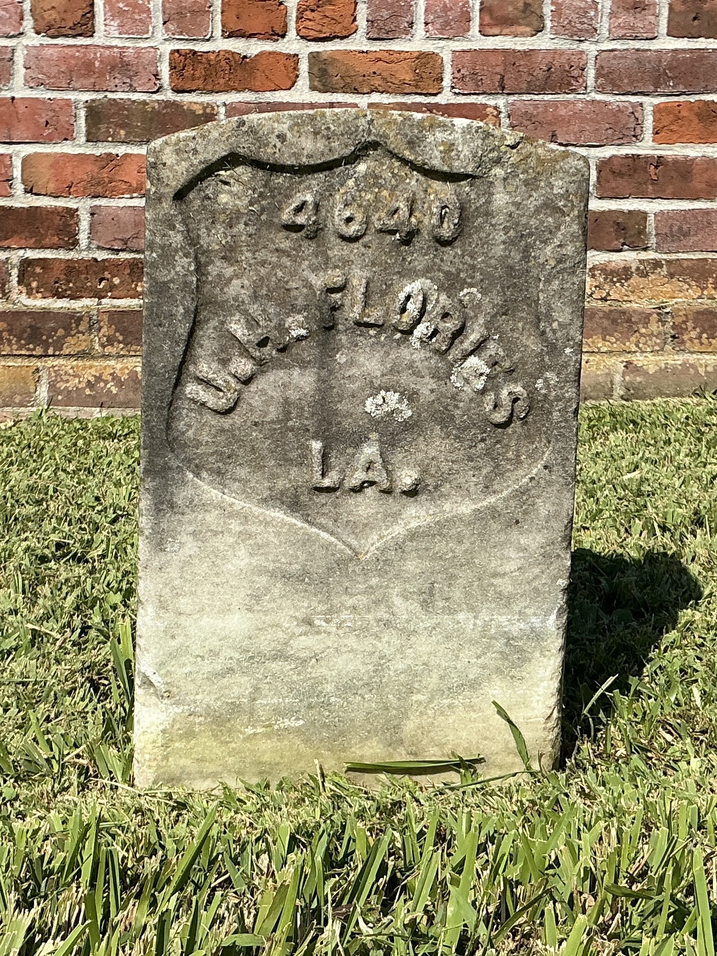 Front of historic upright marble headstone with recessed shield face.