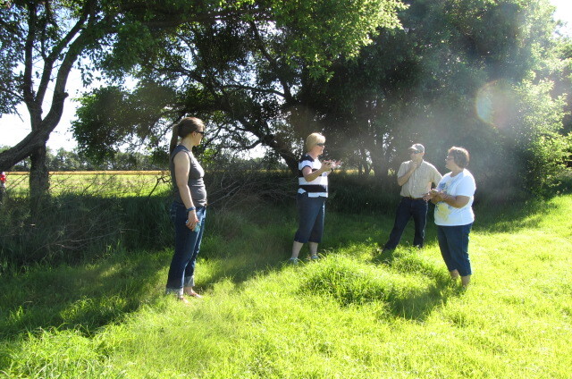 A group of people standing in a grassy field.