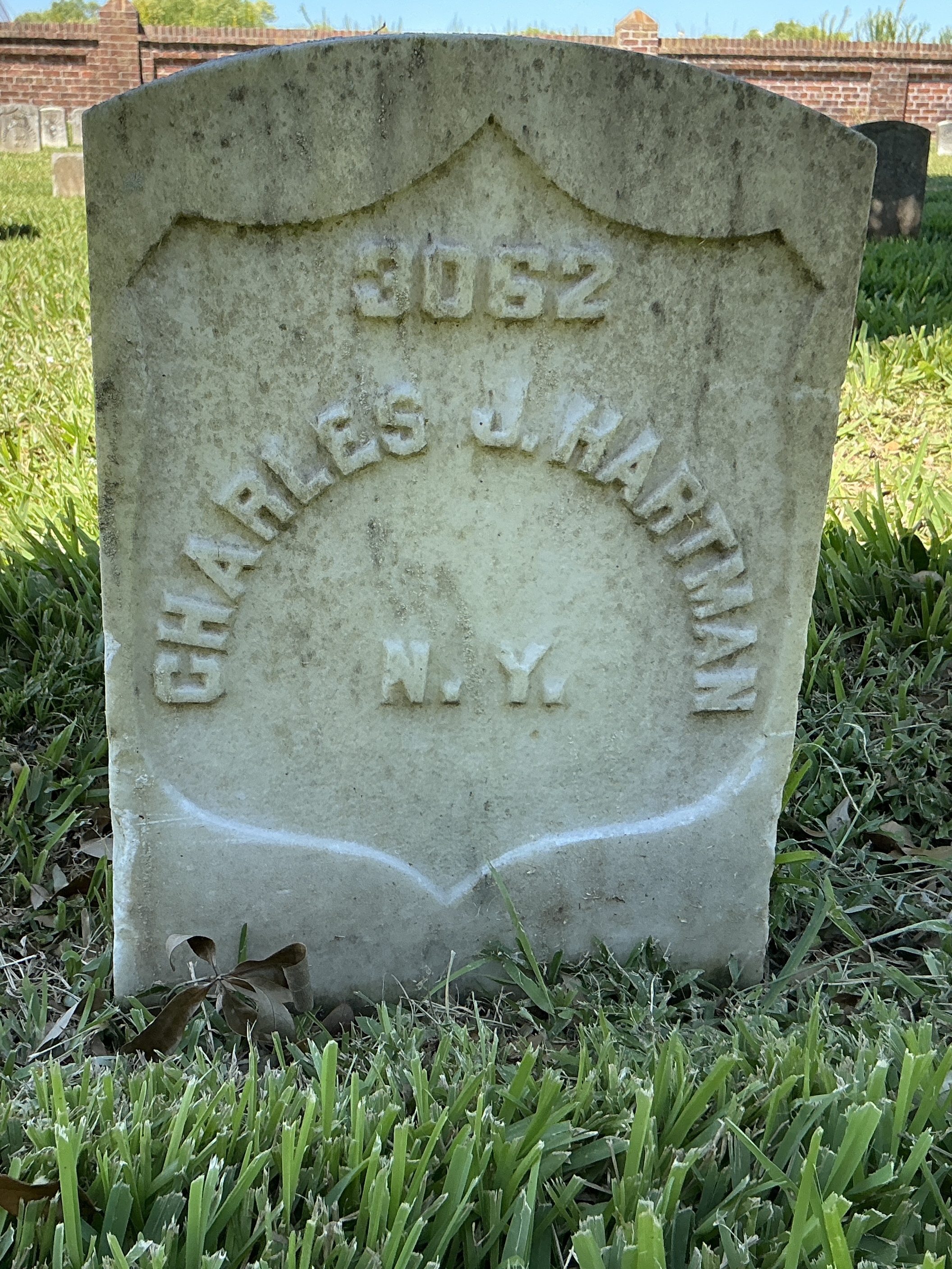 Front of historic upright marble headstone with recessed shield face.