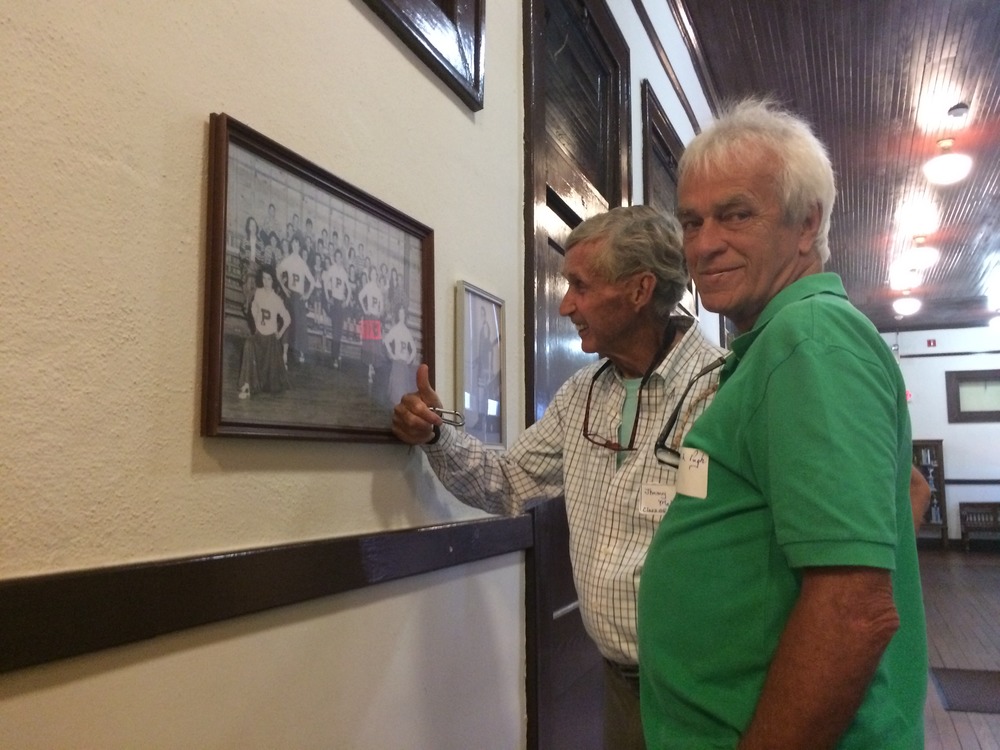 Two Plains High School alumni closely examine a photo to see if they recognize anyone in it.
