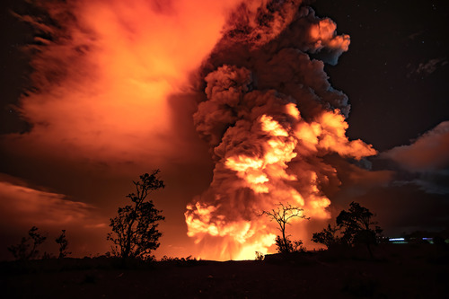 Large plume of an erupting volcano at night