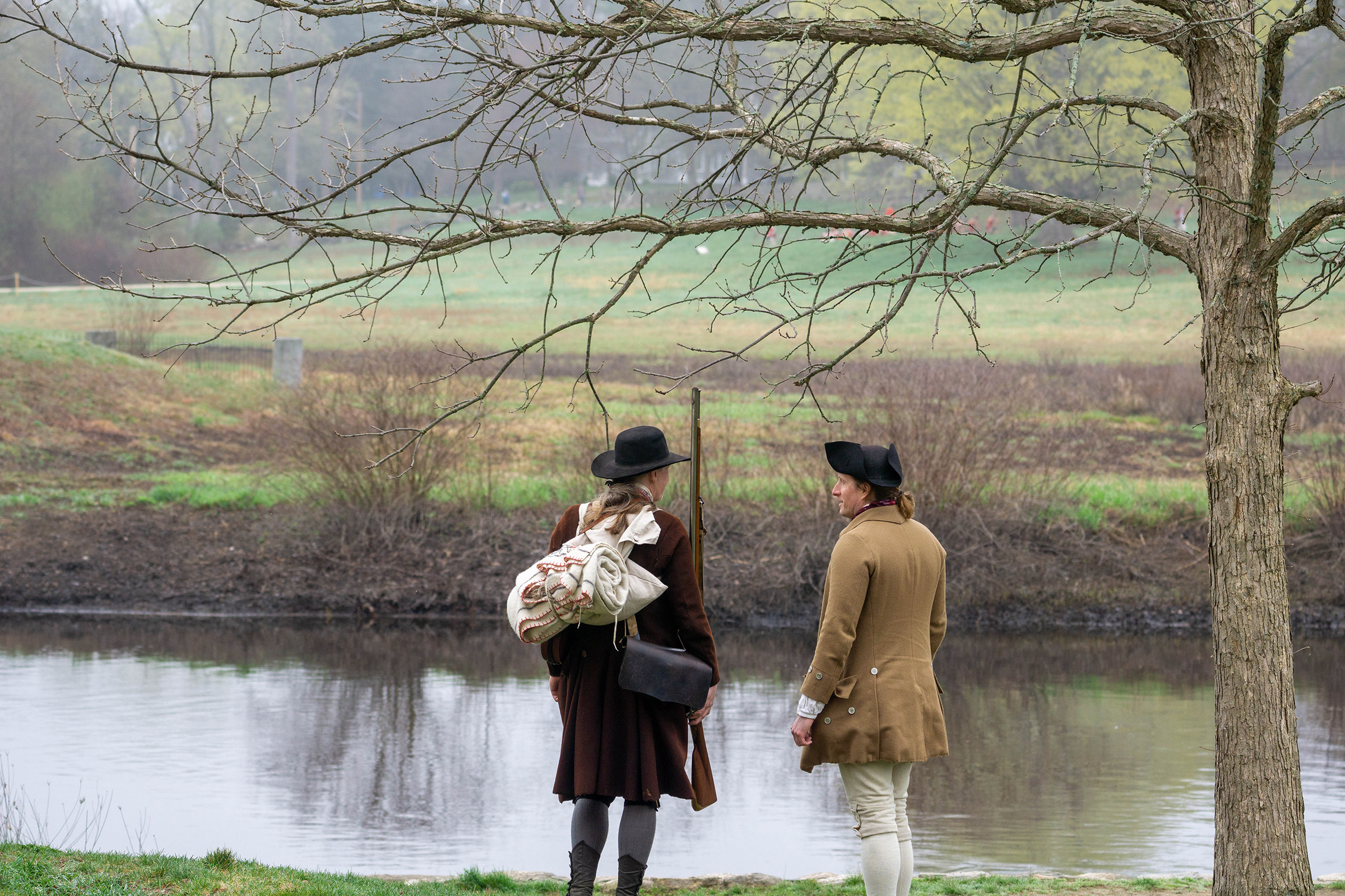 Loyalist guides standing next to the Concord River. 