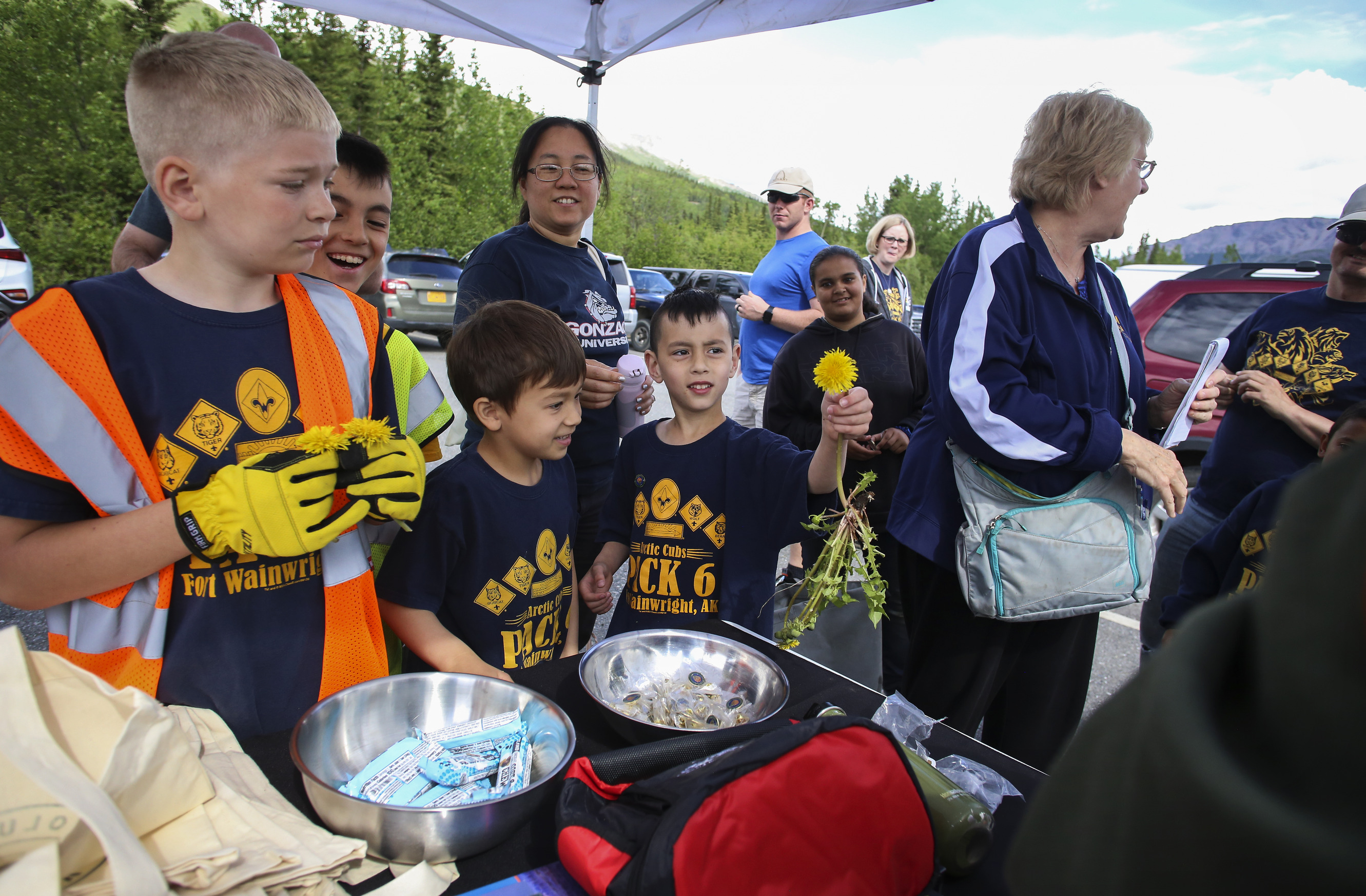 kids and the elderly gather at a parking lot