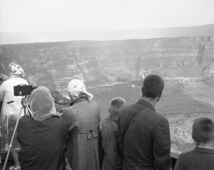 Black and white photo of observers looking at a volcanic crater