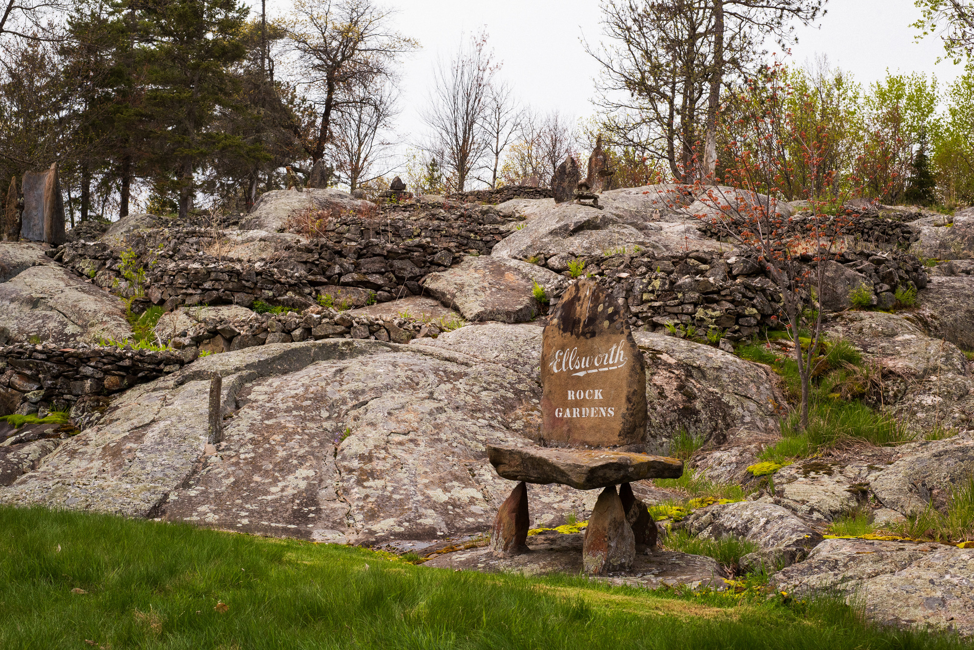 Photograph of rocky hillside with a sign reading "Ellsworth Rock Gardens."