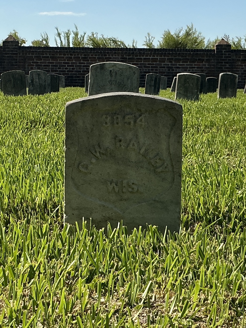 Front of historic upright marble headstone with recessed shield face.