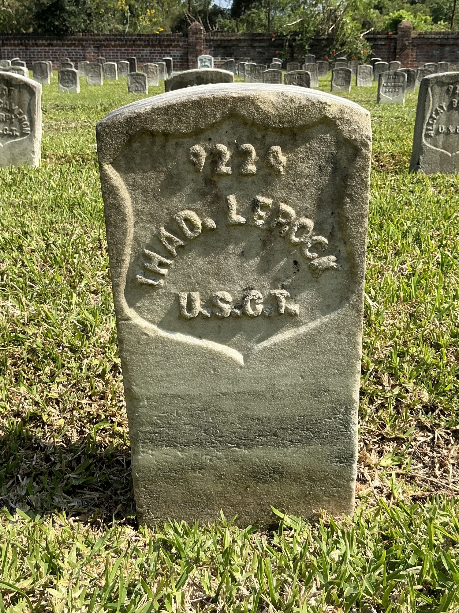 Front of historic upright marble headstone with recessed shield face.