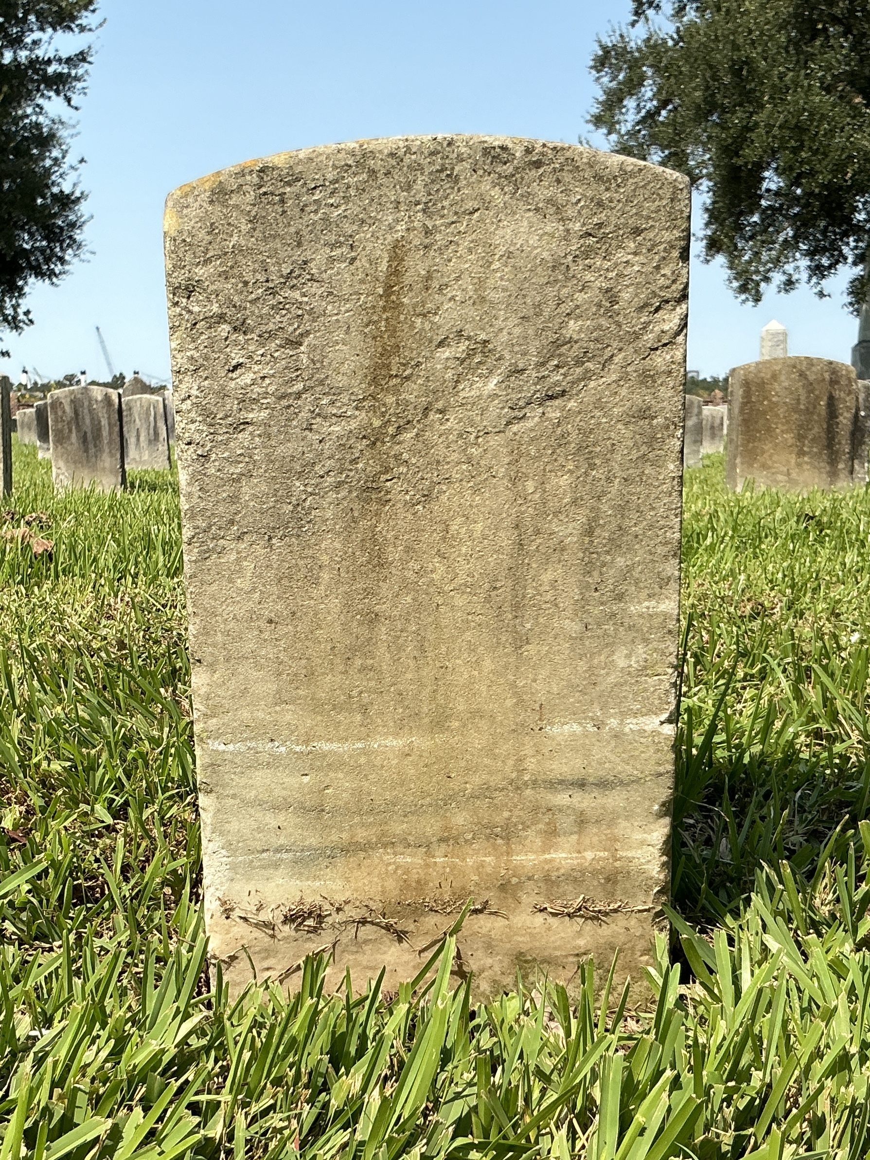 Back of historic upright marble headstone with recessed shield with recessed lettering face.