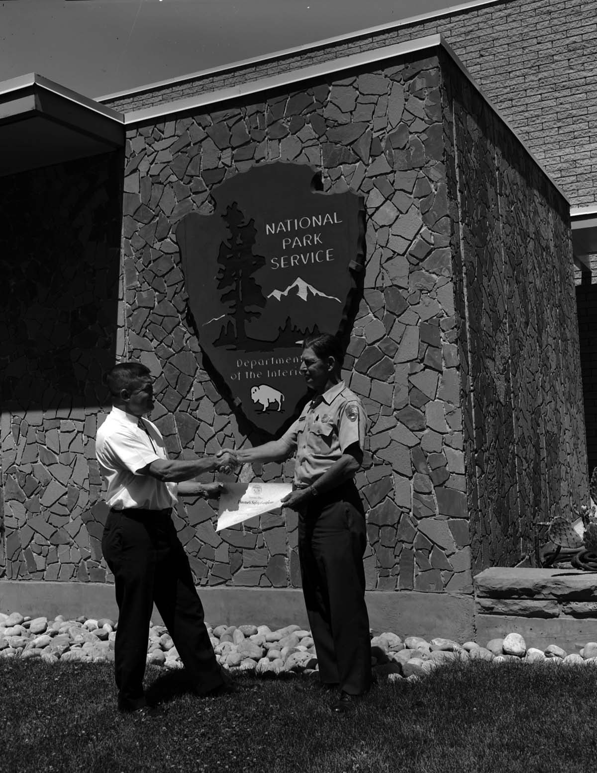 Tom Ela presents Superintendent Warren F. Hamilton with Safety Award, Second Place service-wide, in front of Mission 66 Visitor Center and Museum.