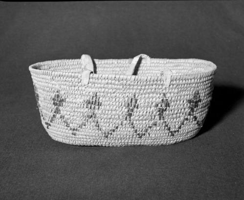 Marie Rozier Collection, Catalog No. 2-CAN-7. Object: Salish carrying basket. Dimensions: 16 x 9 x 6 1/2". Materials: Cedar root, cherry bark, brain-tanned buckskin and smoke buckskin, cotton cloth. Technology: Rather rude construction, lots of split stitches; imbricated design; leftward coil direction. Collection History: Bought at Yellow Barn at Salmon Arm, British Columbia, 1969. Photographed by Michael Dixon, December 1982. Catalogued by Craig Bates and Barbara Beroza. Yosemite Collections, National Park Service.