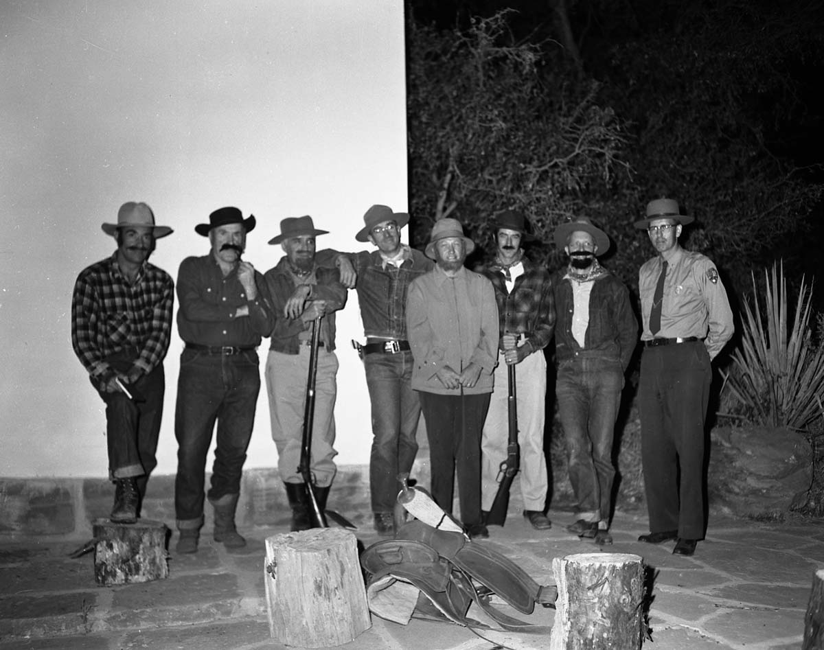 Staff in pioneer costumes and ranger in uniform posing on stage during campfire program. Campfire Day, September 19, 1957 at the South Campground amphitheater.