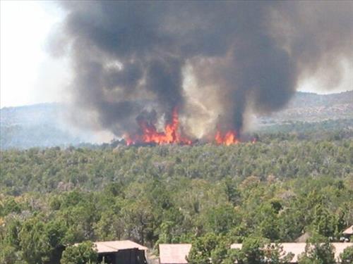 Full fire with black smoke advancing on buildings on the first day of Long Mesa Fire, Mesa Verde National Park, July 29, 2002