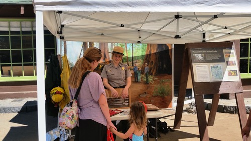 A ranger talks with a woman and child