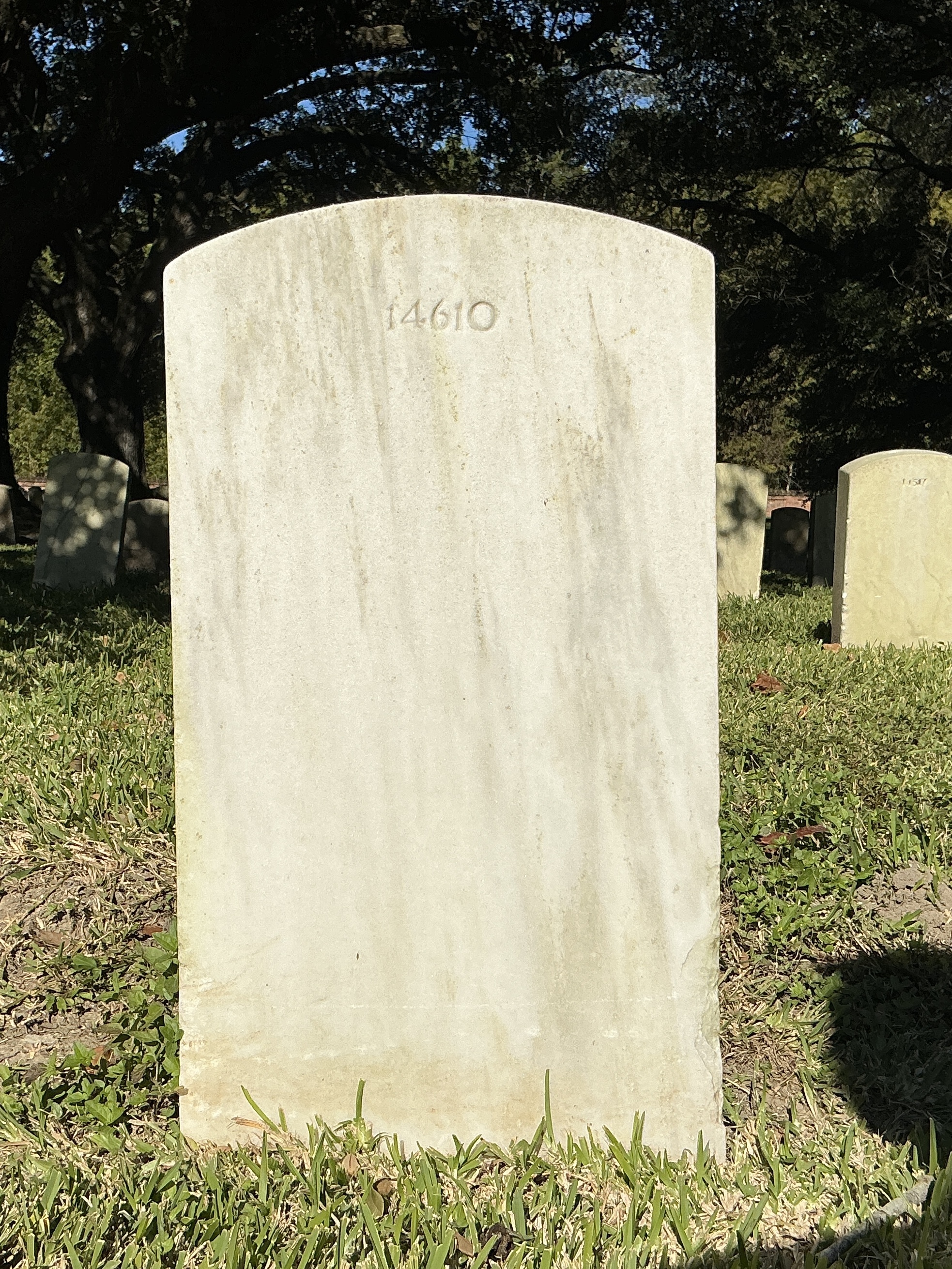 Back of upright marble headstone with flat face.