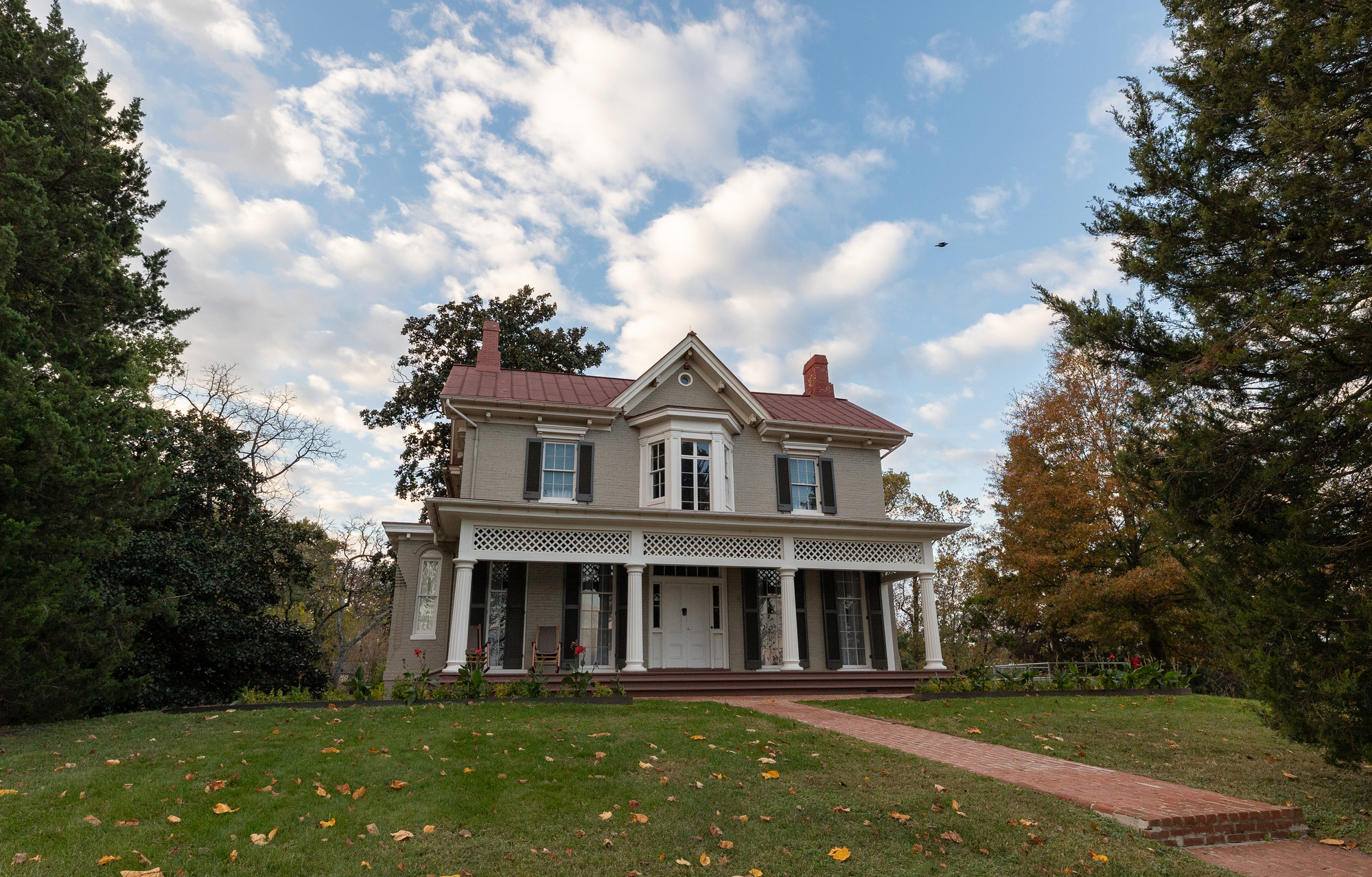 A large house surrounded by trees and a large lawn. 