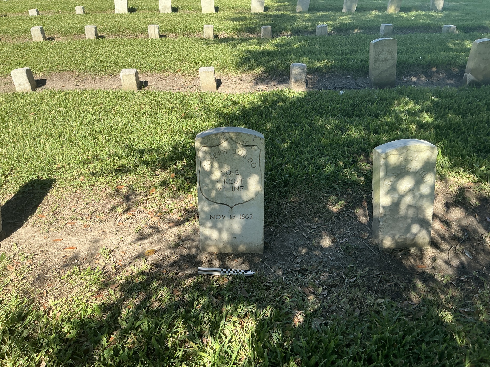 Extra image of historic upright marble headstone with incised shield face.