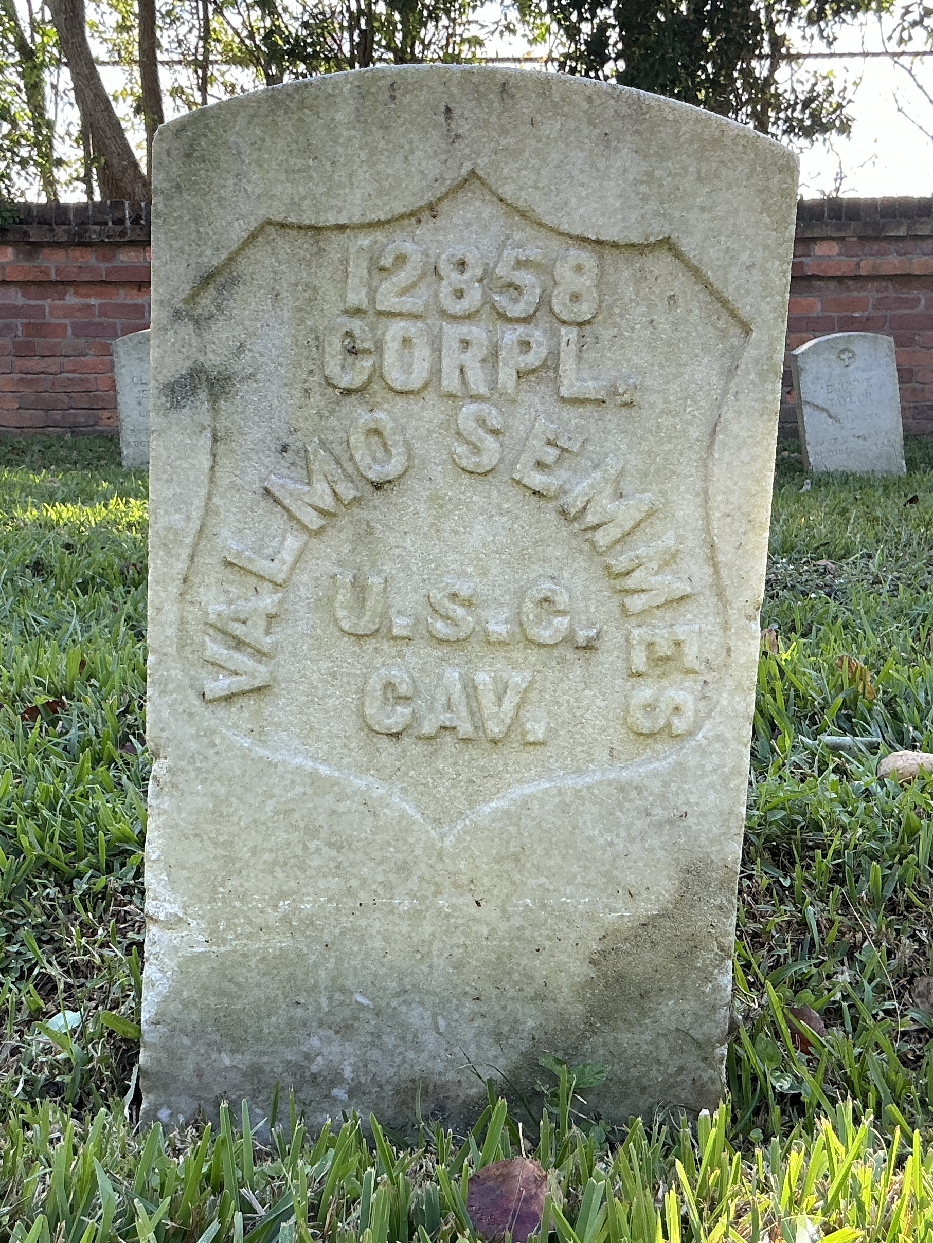 Front of historic upright marble headstone with recessed shield face.