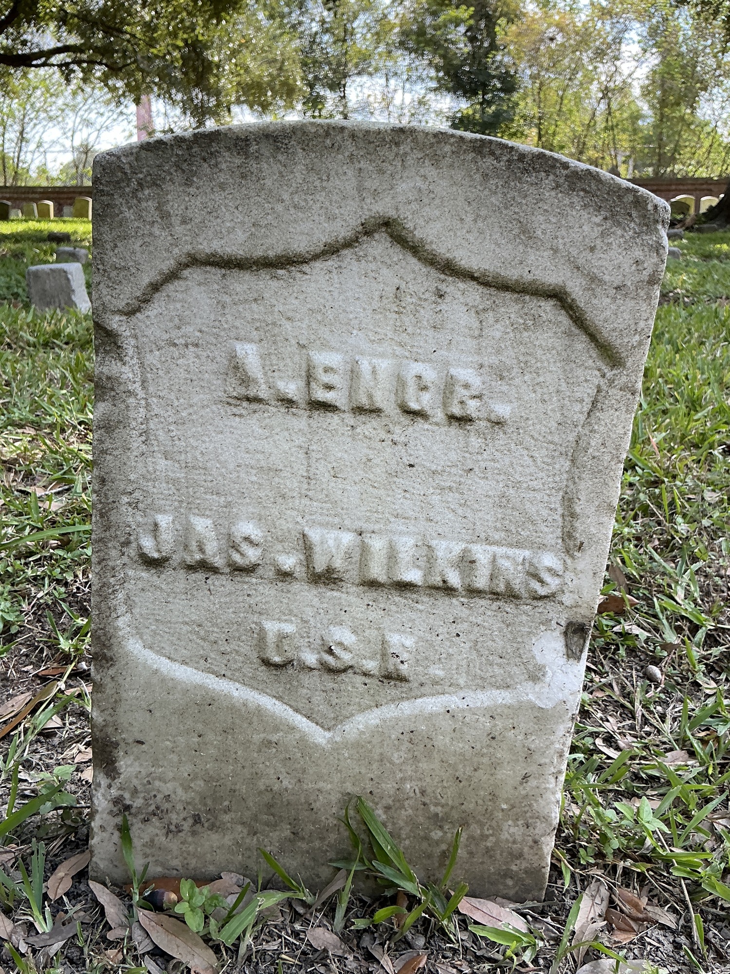Front of historic upright marble headstone with recessed shield face.